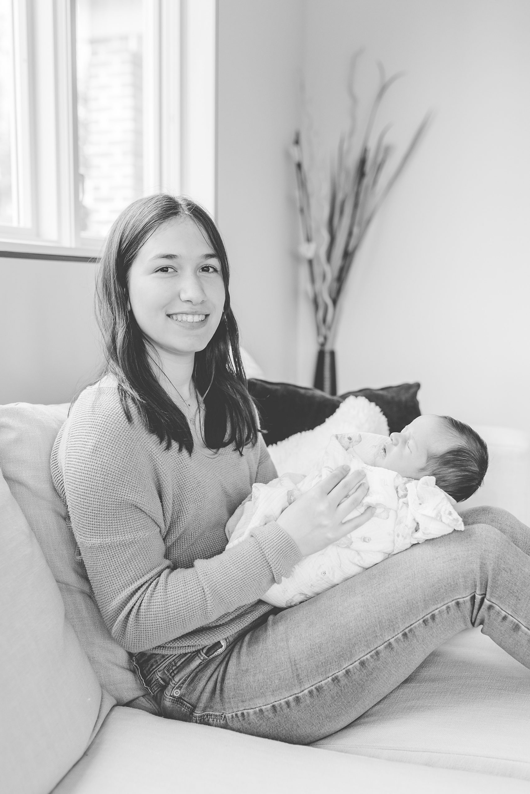 teen-age sister holds new baby sister 