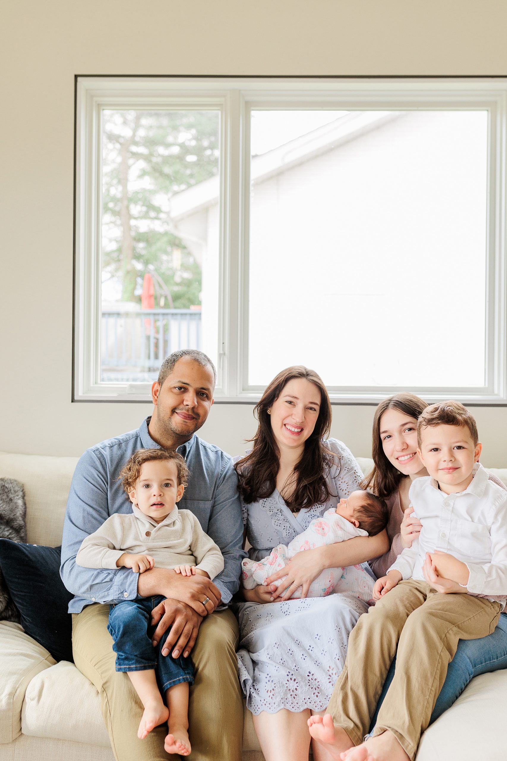 family of six sits together on couch during Silver Spring MD newborn lifestyle session