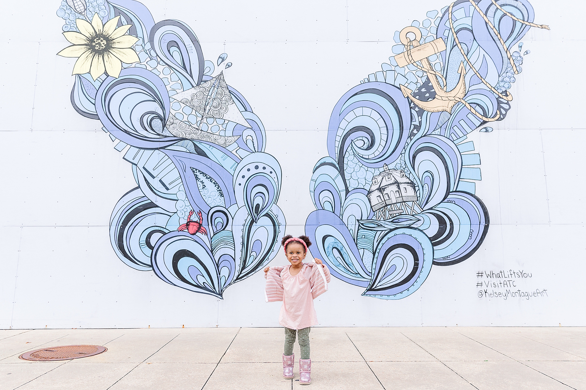 toddler stands by blue butterfly during Annapolis family portraits