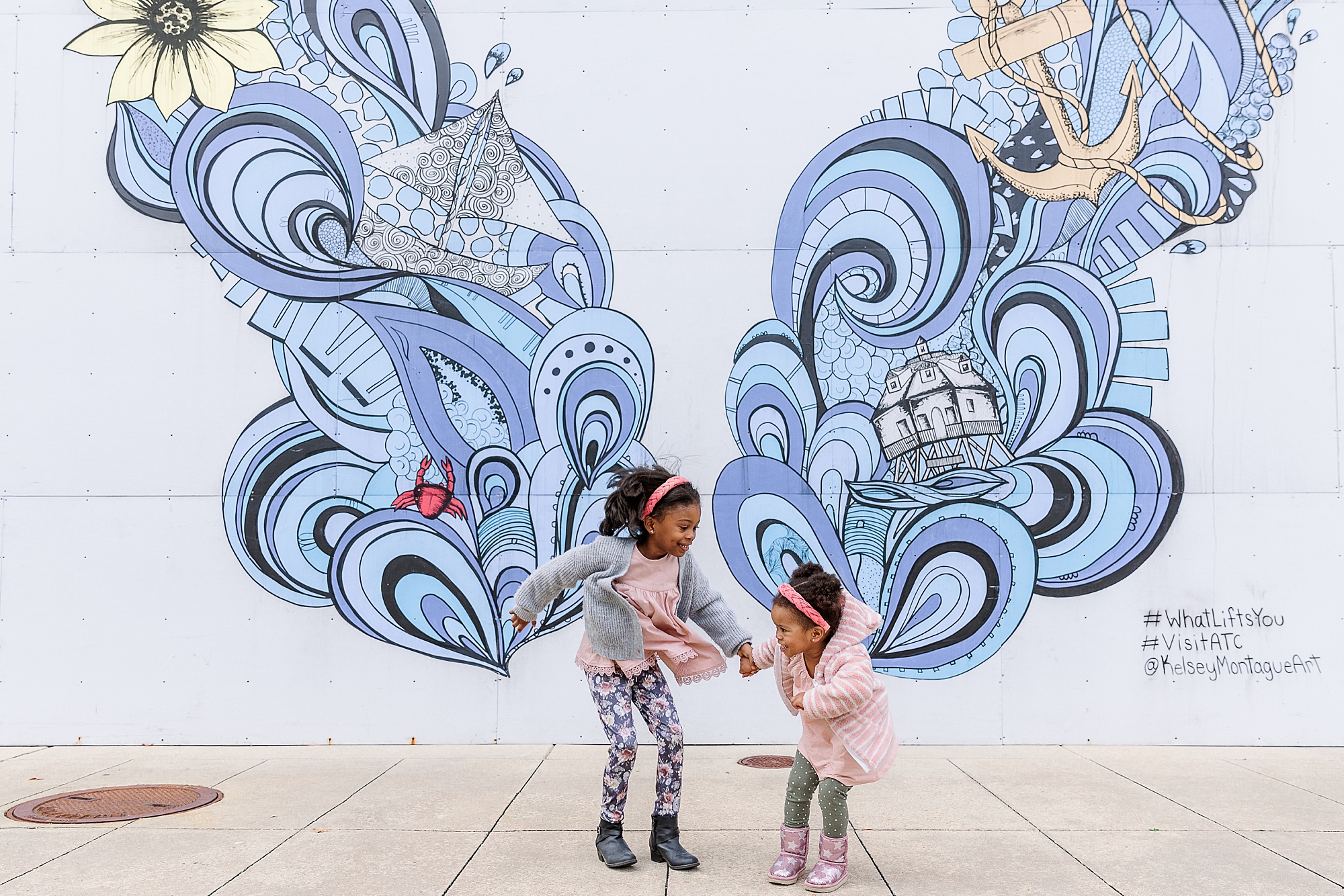 sisters play by blue butterfly mural