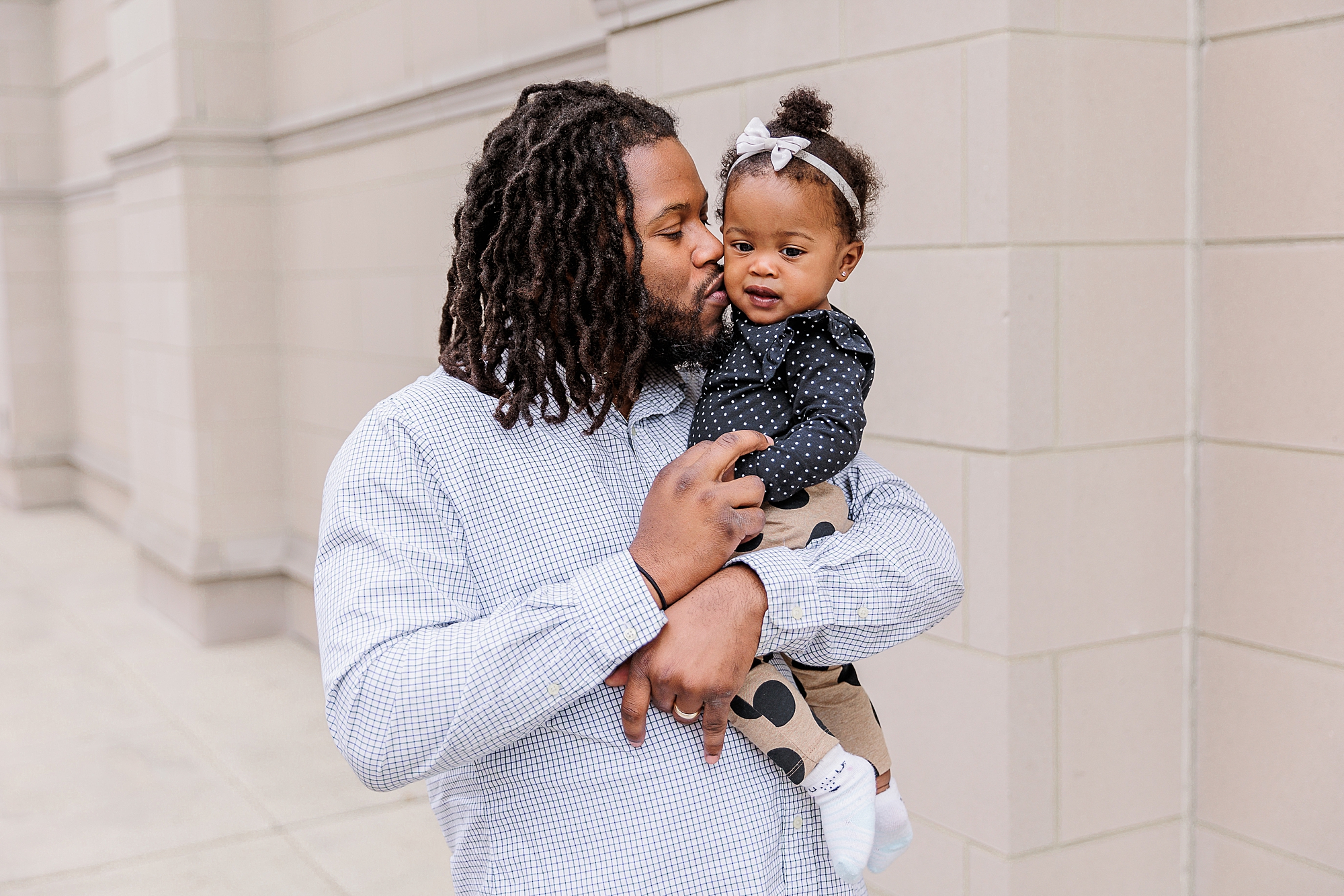 man kisses his daughter's cheek during Annapolis family portraits