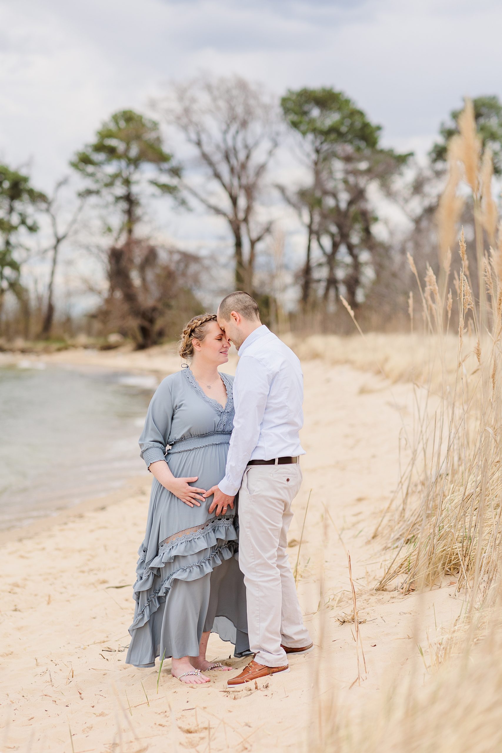 husband and wife hug on Eastern Shore during maternity photos
