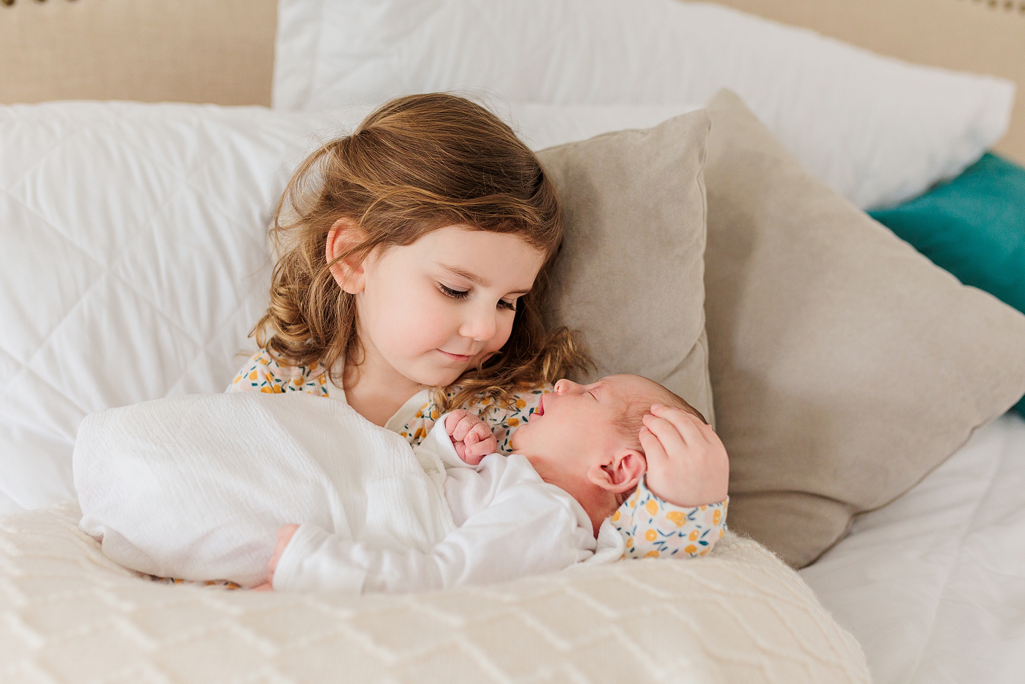 big sister holds newborn during newborn photos at home 
