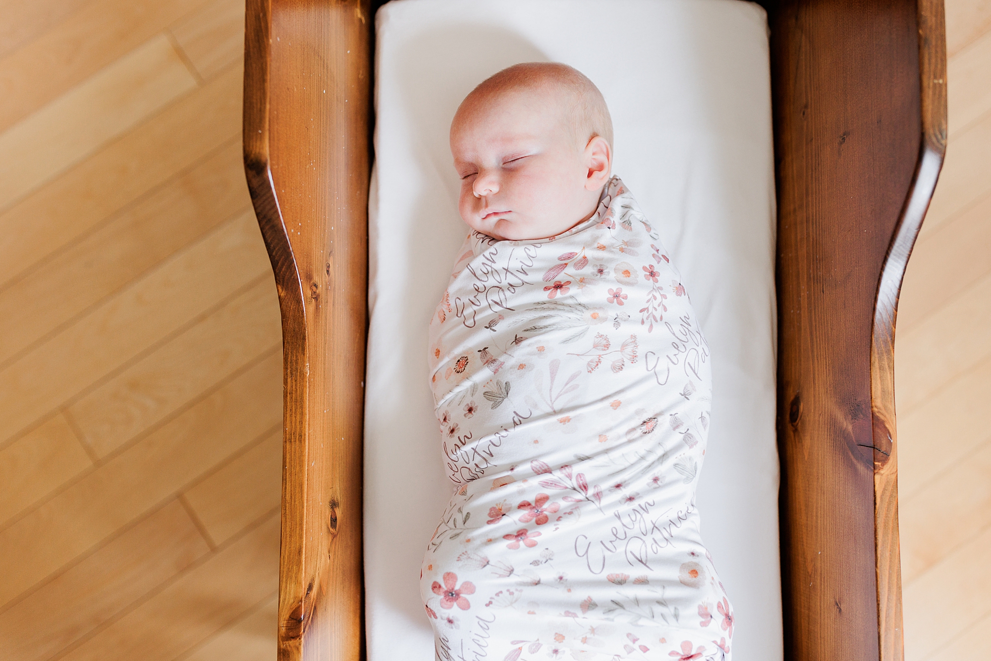 baby girl sleeps in family cradle during lifestyle photos at home