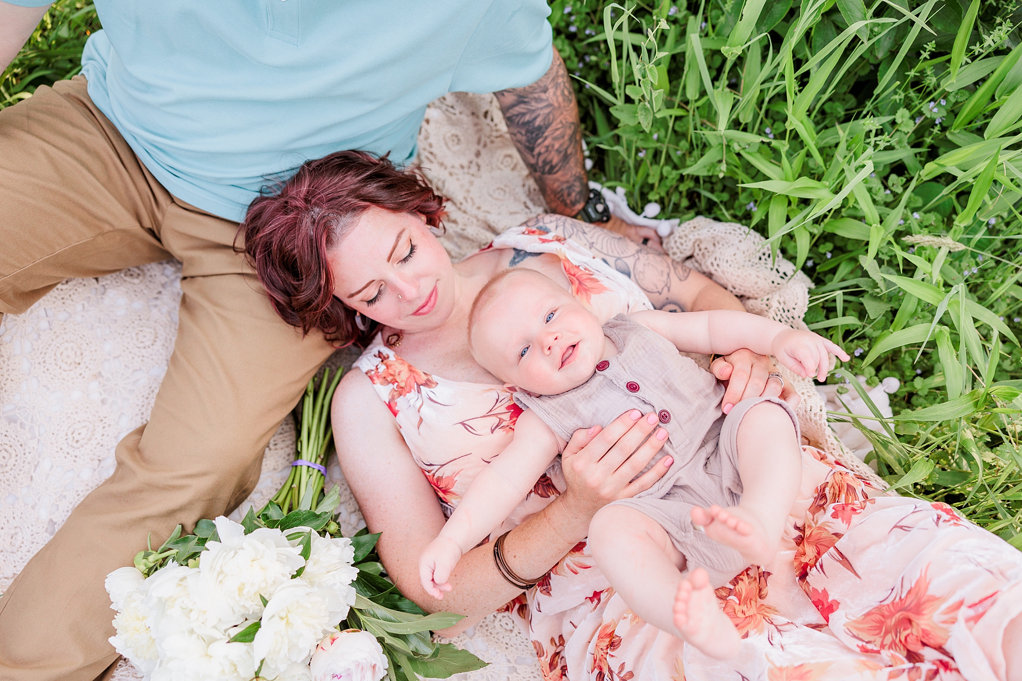 mom and son lay down in field with dad during Seneca Creek Park parenthood portraits