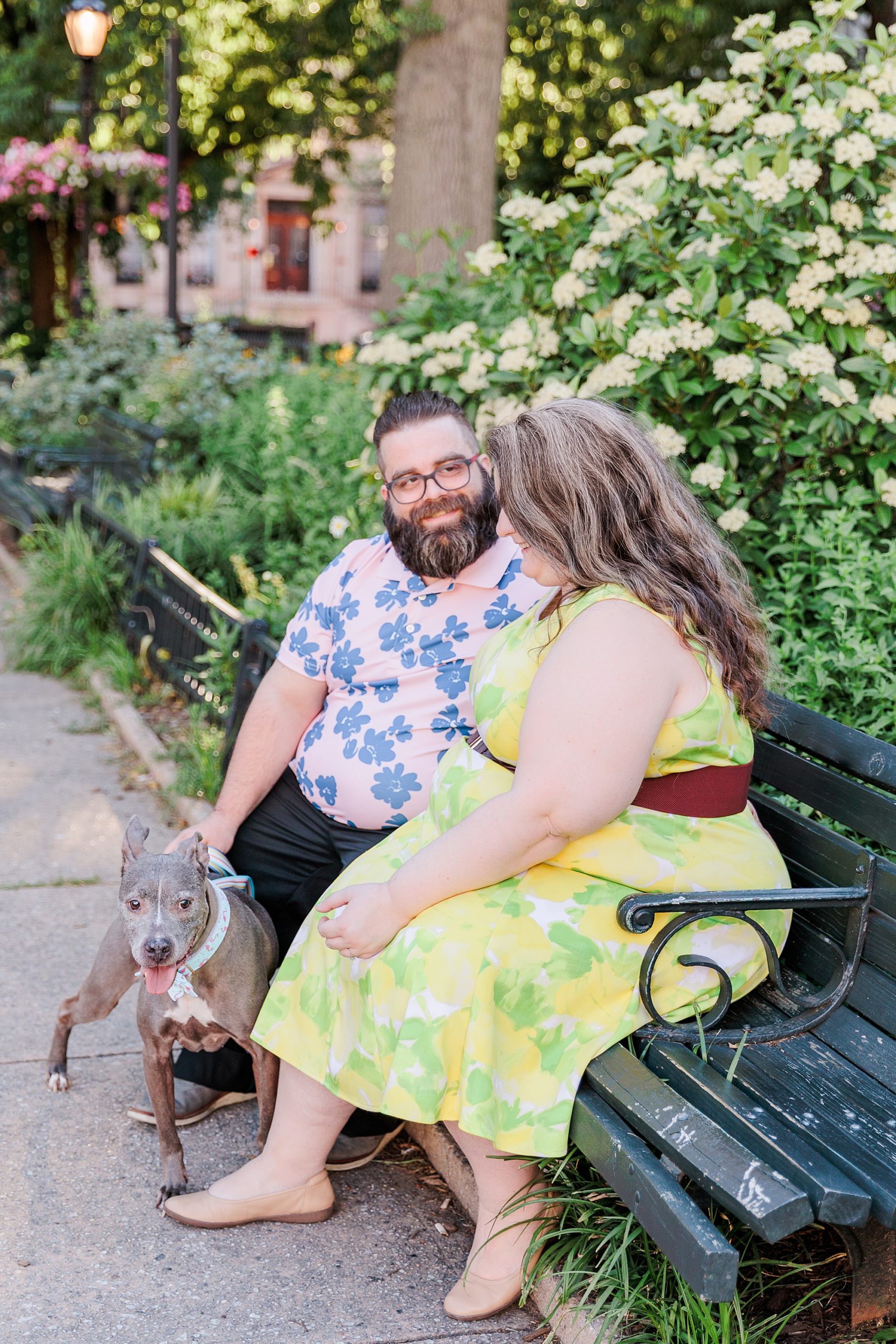 couple sits on park bench during Baltimore family portraits