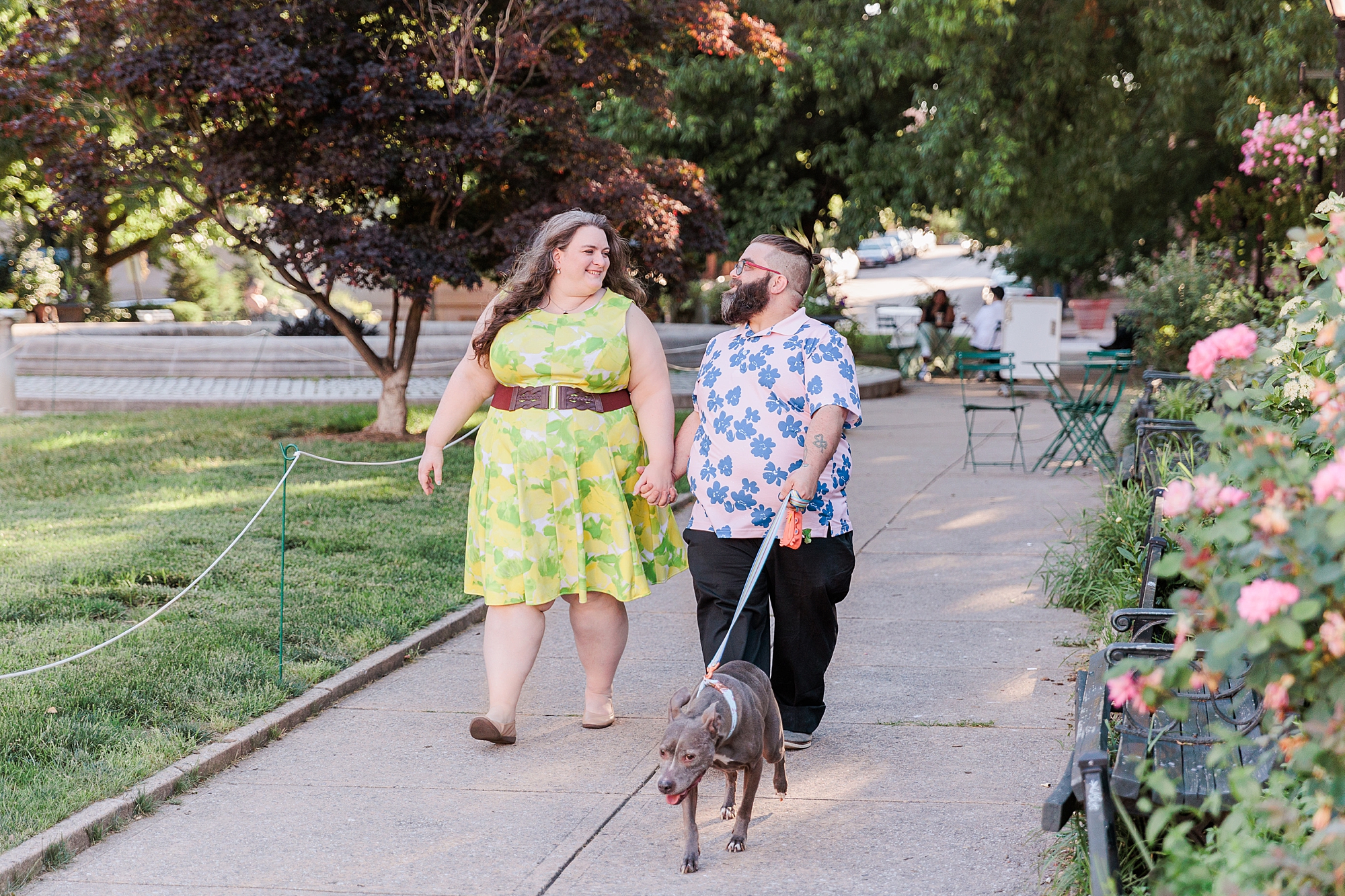 couple walks with dog during Baltimore family portraits at in Mt Vernon