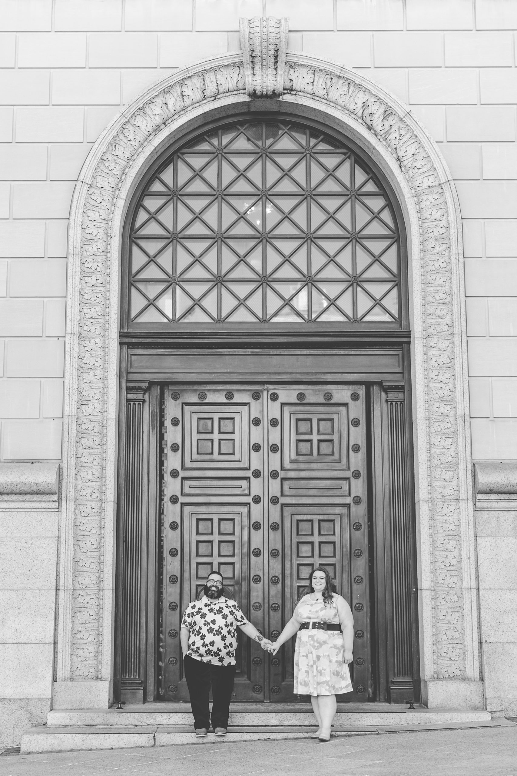 married couple holds hands by door during Baltimore family portraits in Mt Vernon