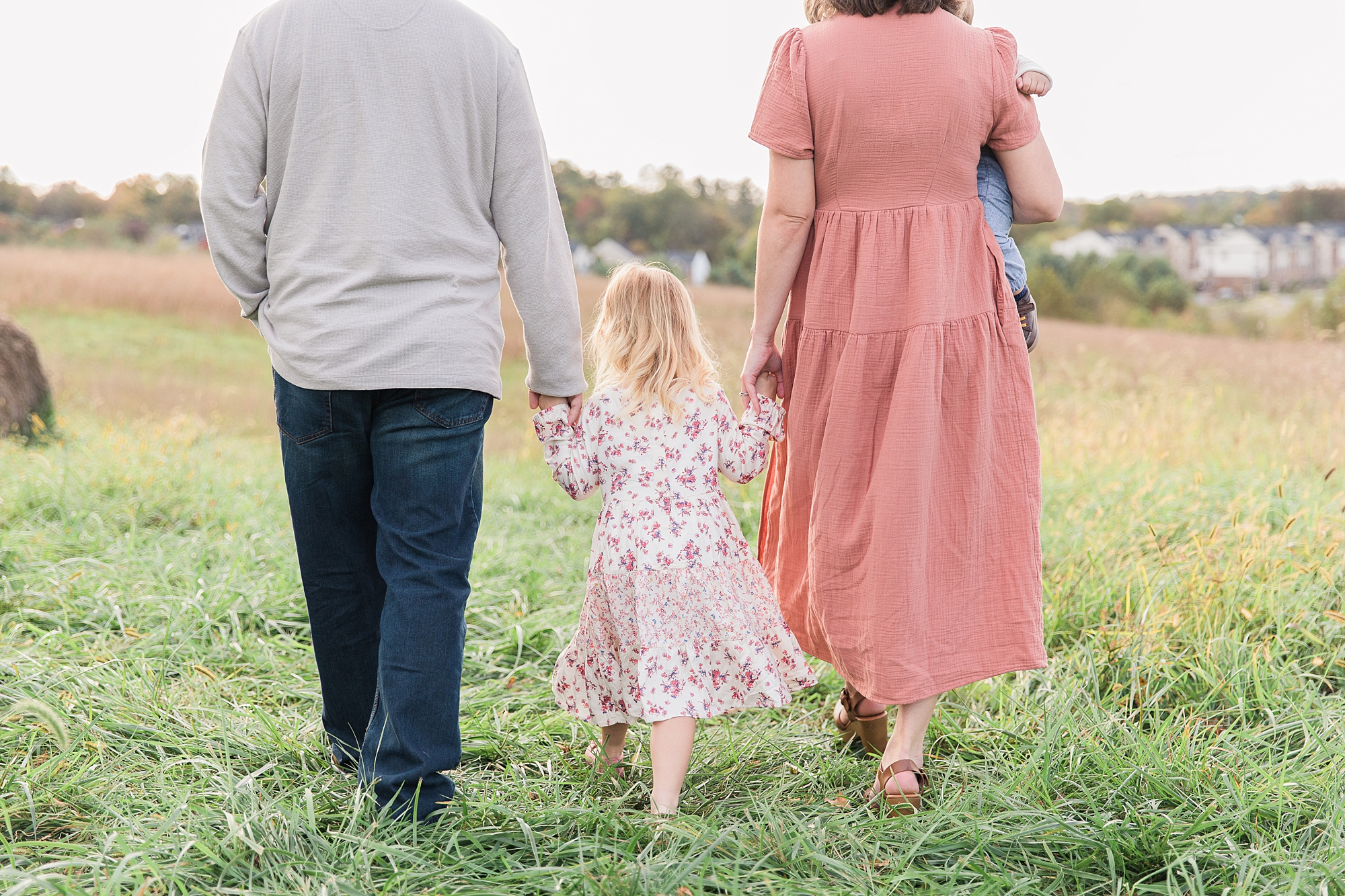 family walks through field during fall family photos