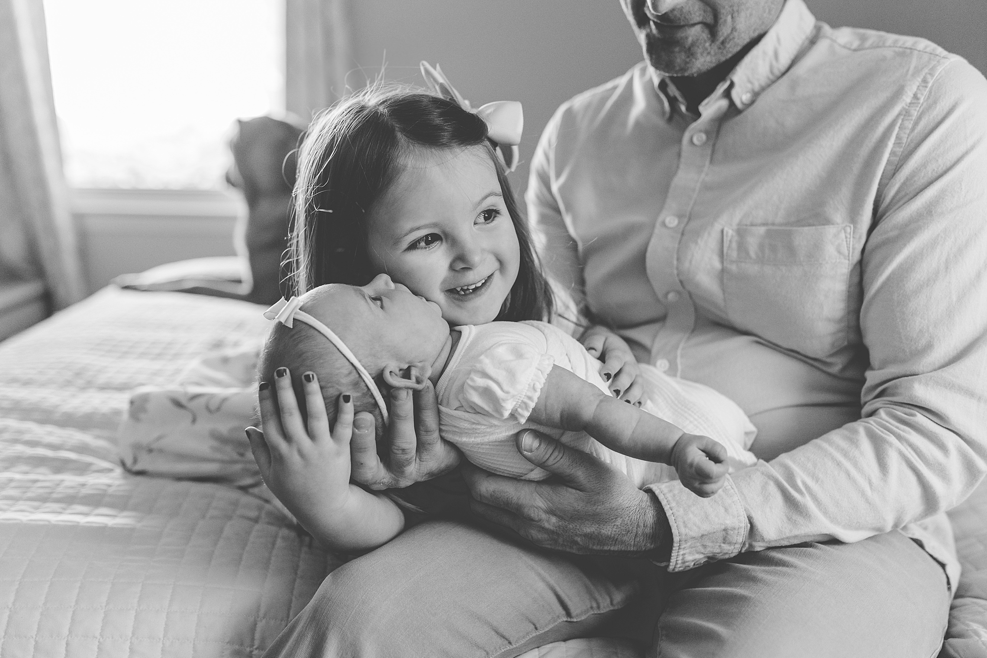 big sister holds new baby during Annapolis MD lifestyle newborn session