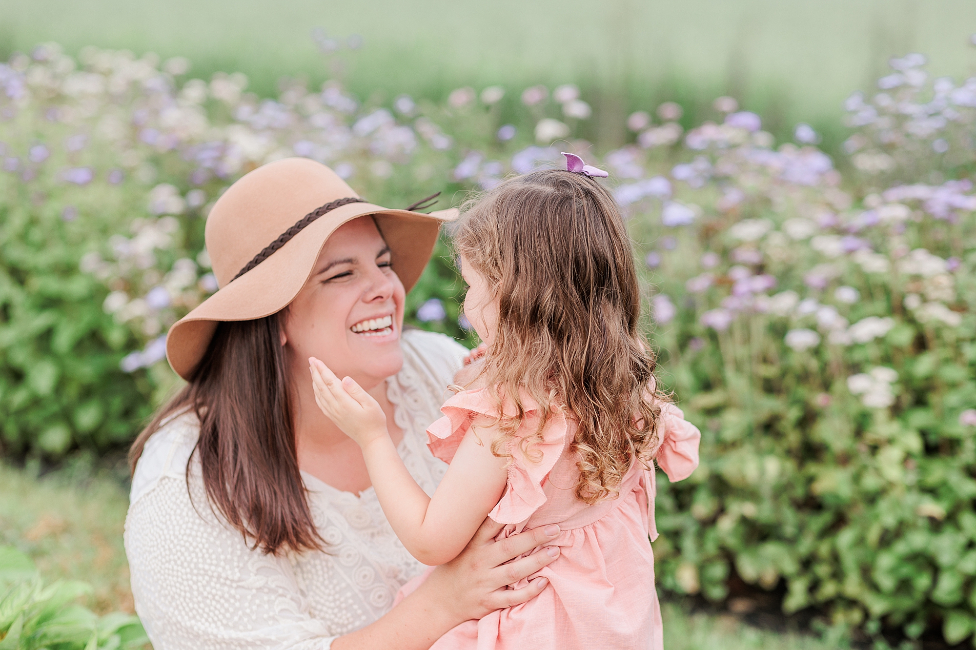 mom laughs with toddler during spring family photos