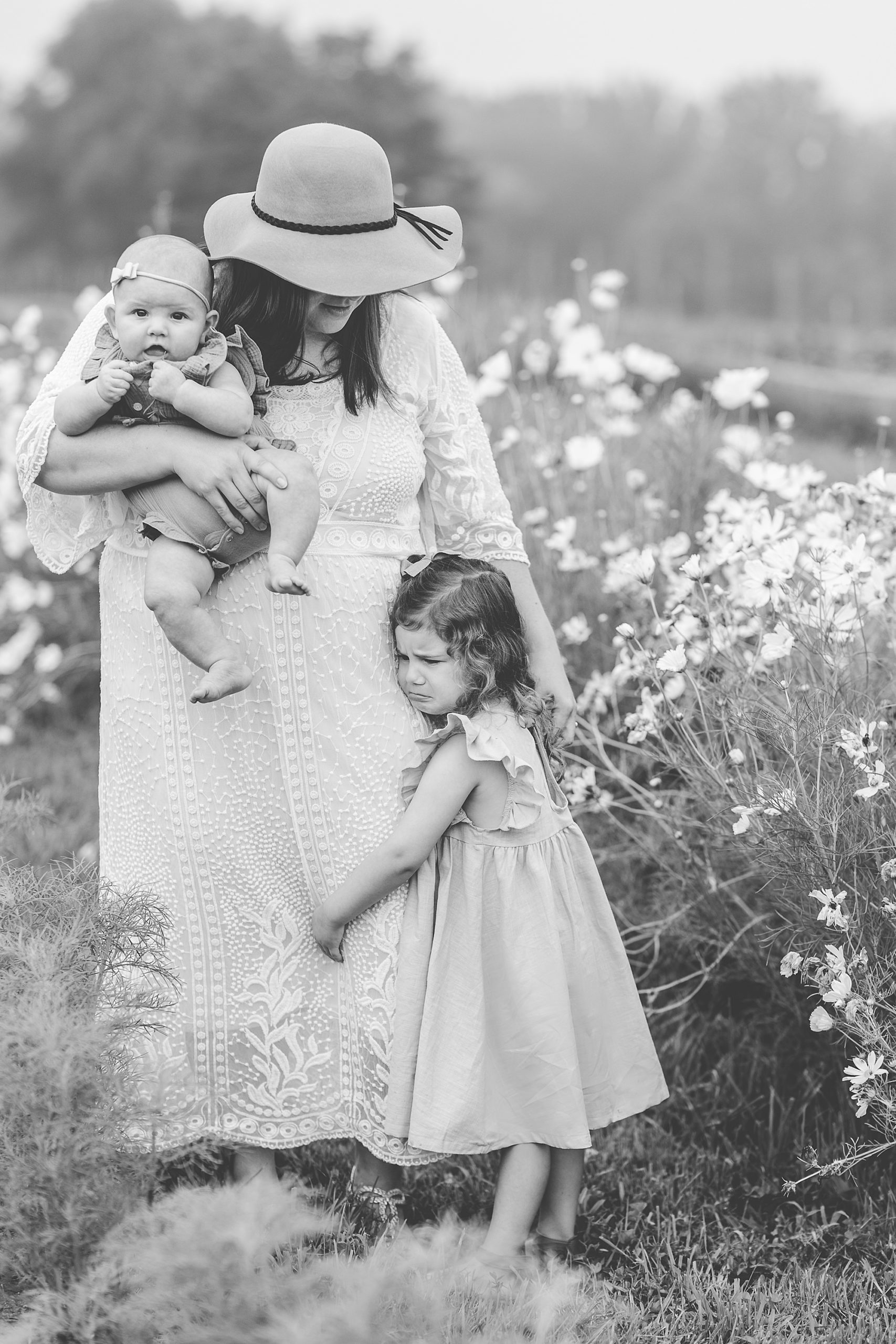 mother in floppy hat walks with daughters at Castle Bridge Farm