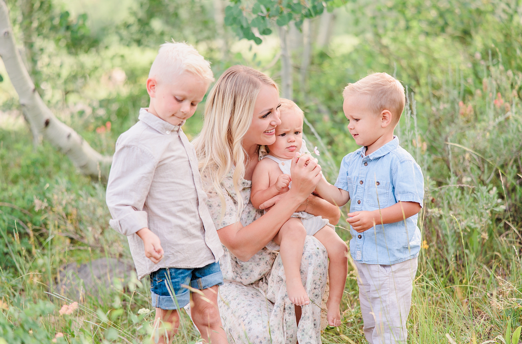 mom holds three kids during family photos