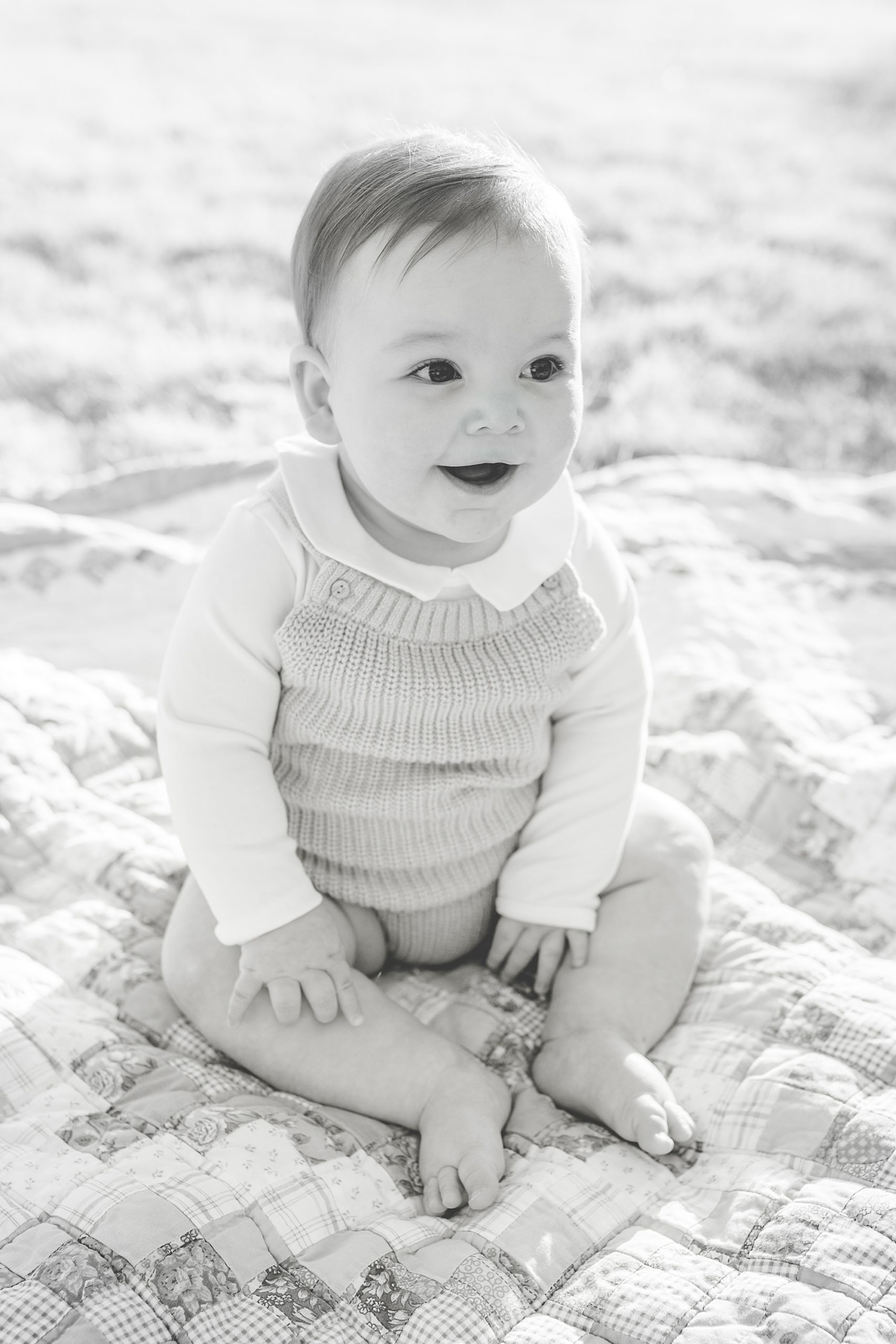 baby sits on quilt during milestone portraits