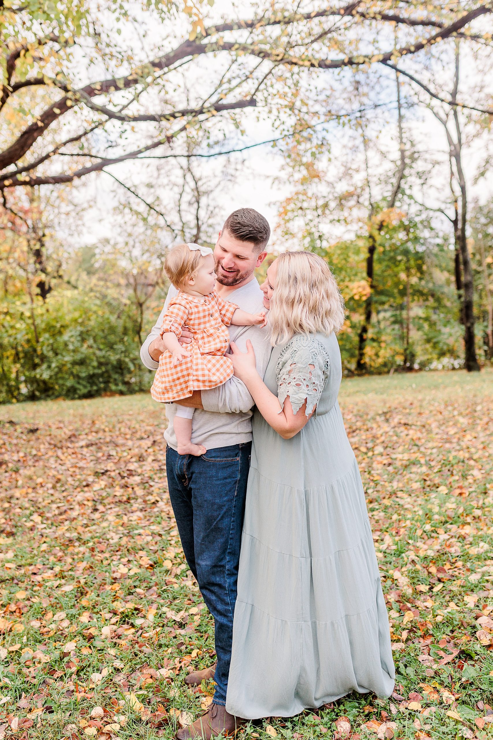 parents look at little girl during fall family photos