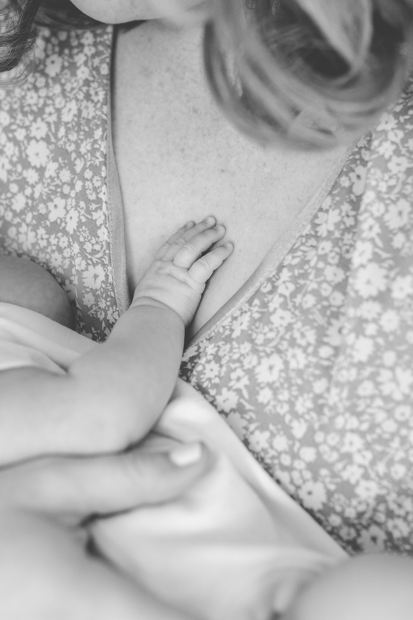 baby lays hand on mom's chest during lifestyle newborn session
