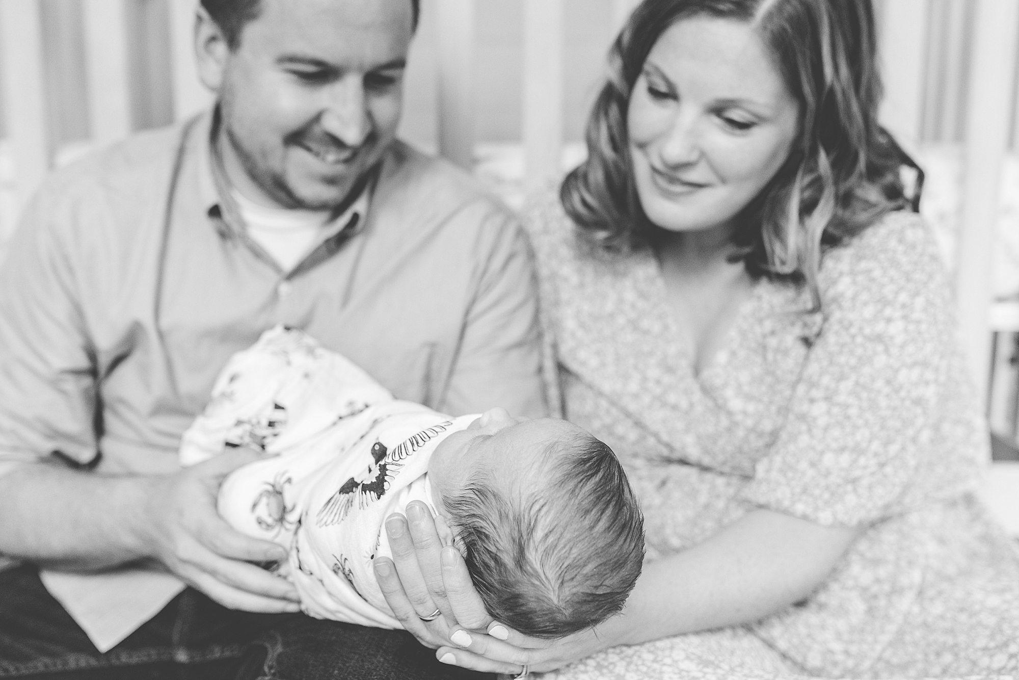 new parents look down at baby girl during lifestyle newborn session