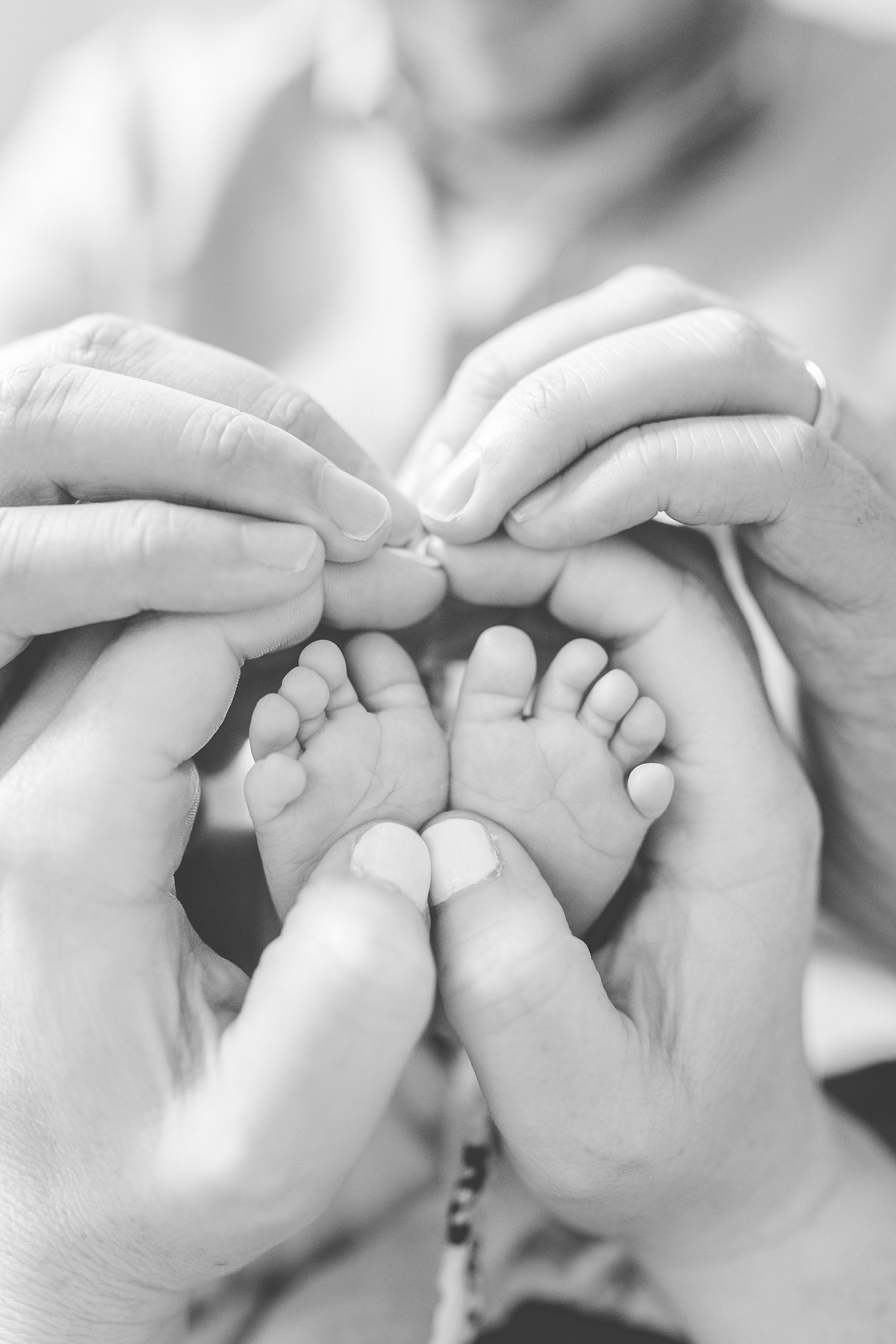 parents make heart around baby's feet