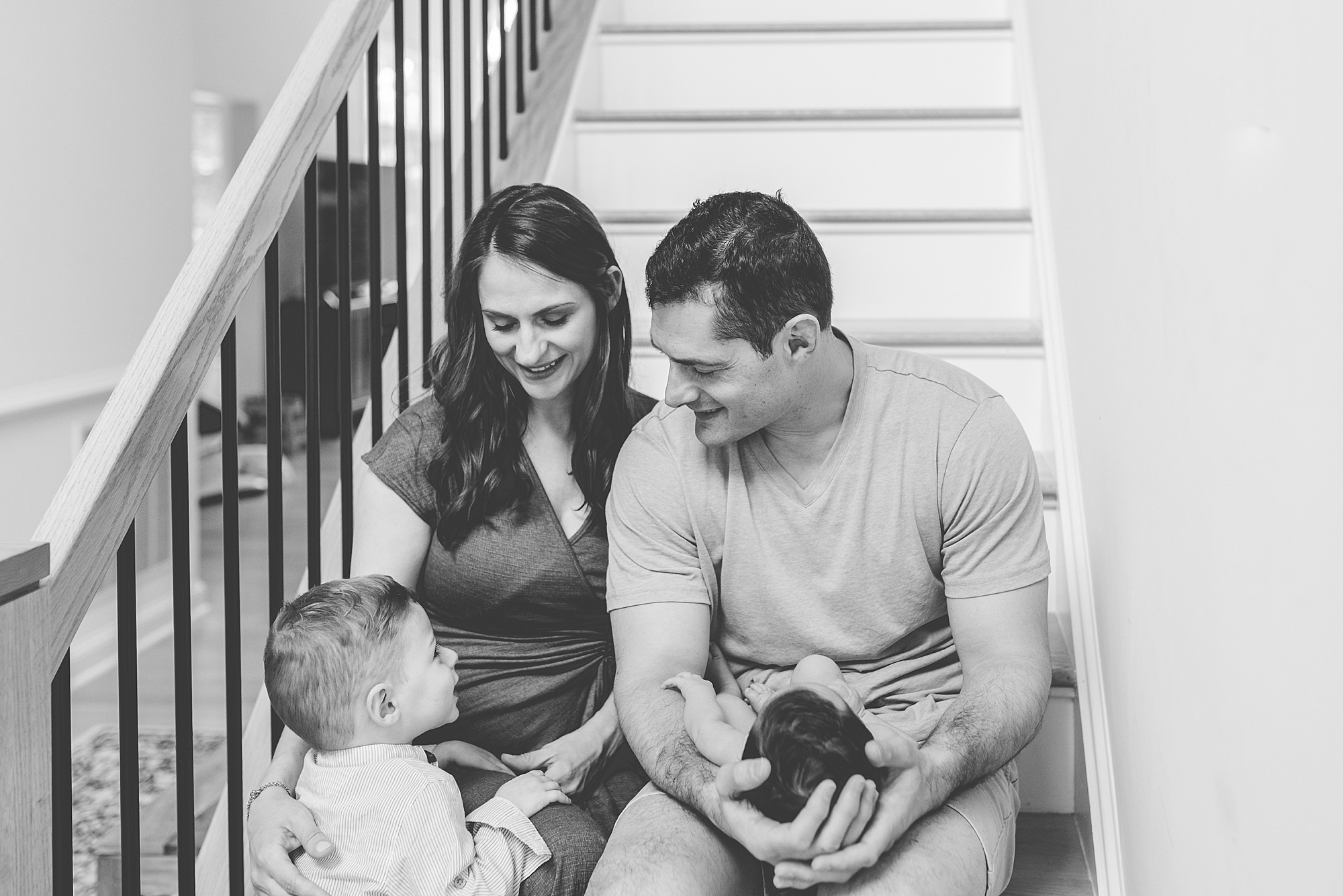 family of four sits together during Clarksville MD lifestyle newborn session
