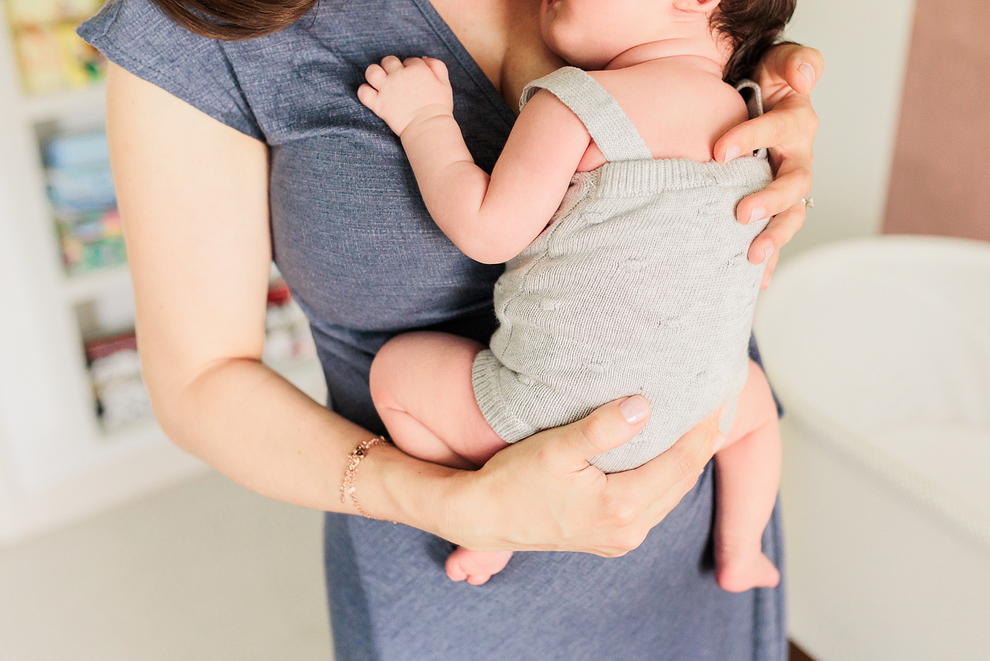 mom hugs baby to chest during newborn photos 