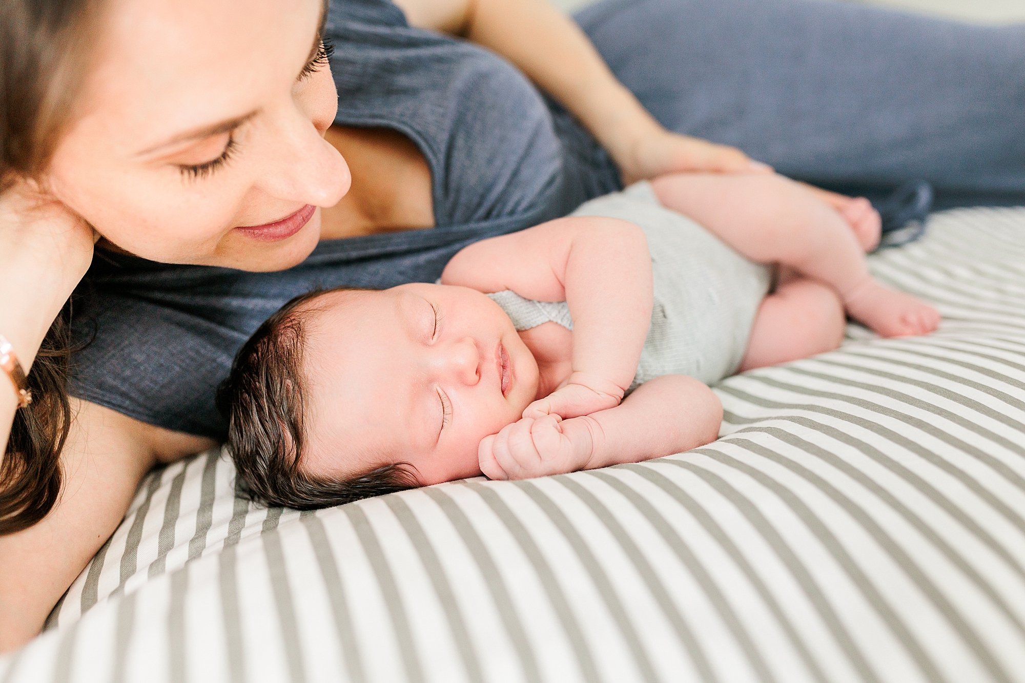 mom lays with newborn baby girl during Clarksville MD lifestyle newborn session