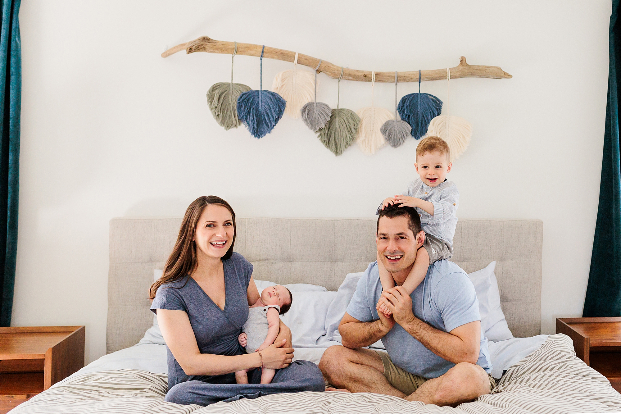 family of four sits on bed together during Clarksville MD lifestyle newborn session
