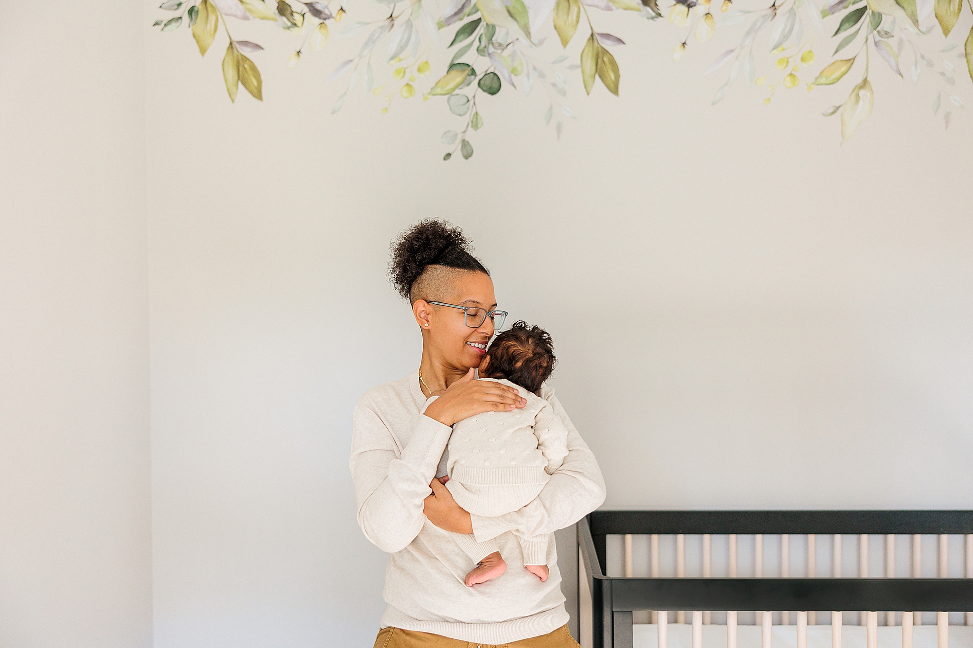 mom hugs baby in nursery during lifestyle newborn session