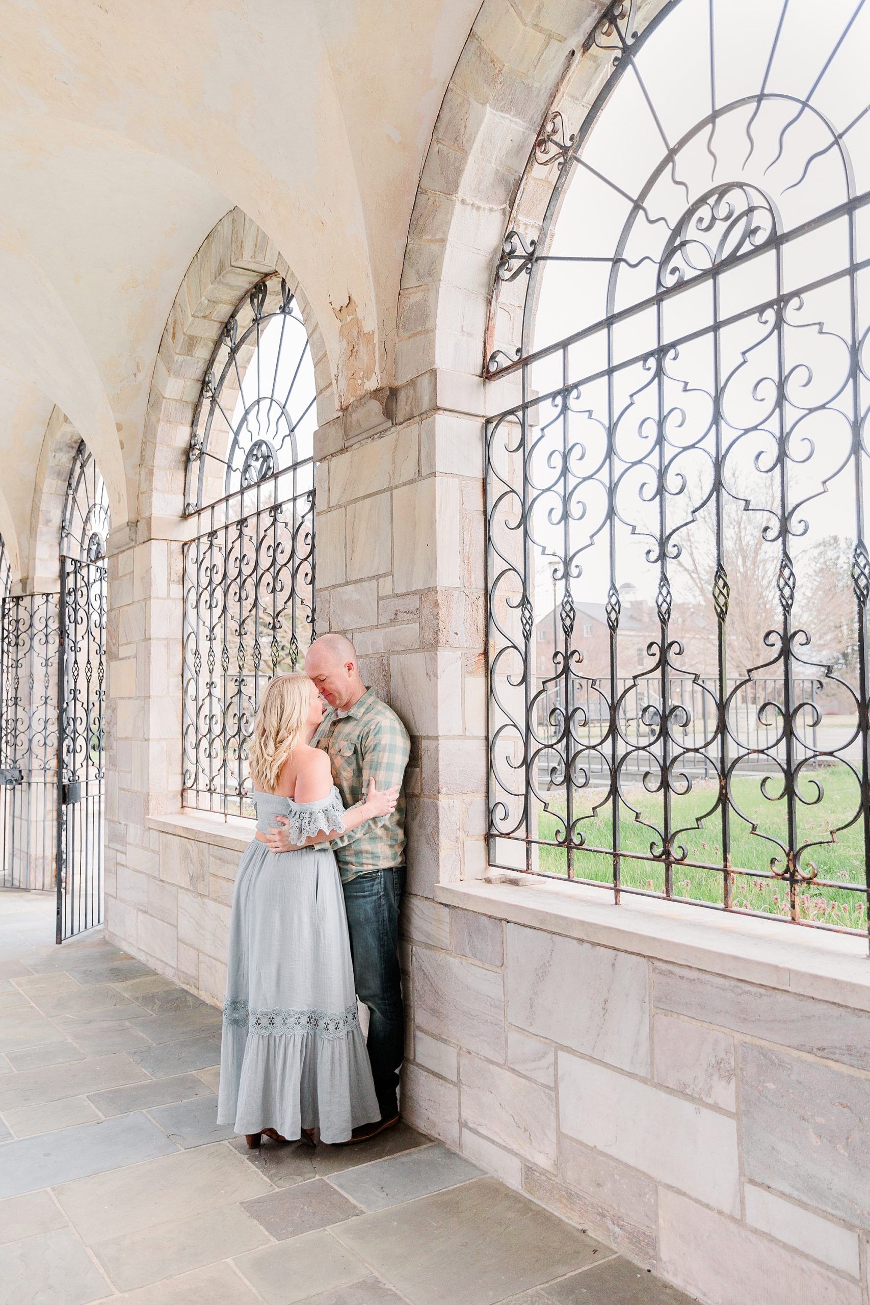 married couple leans against stone window in Howard County MD