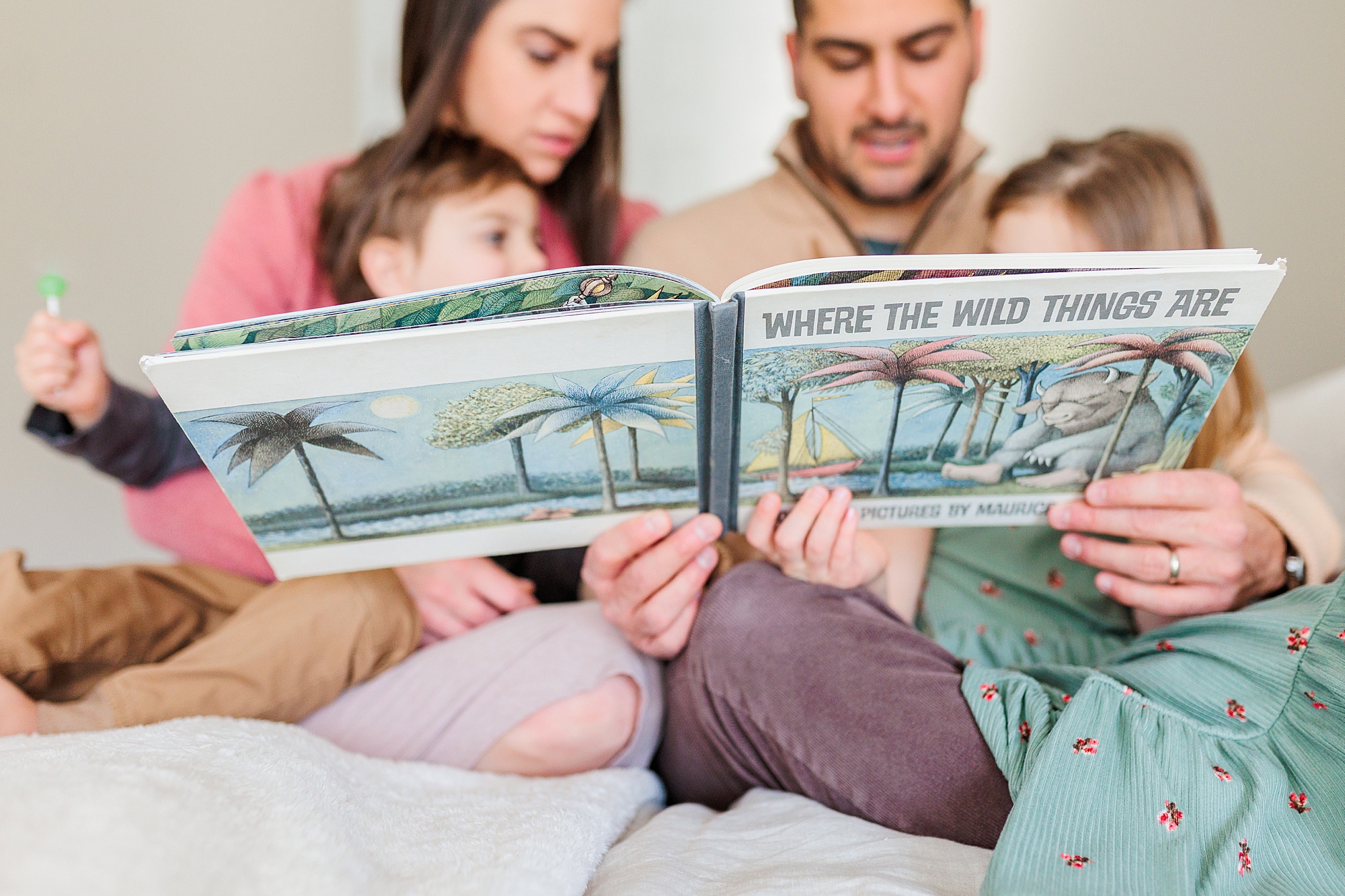 family reads Where the Wild Things Are during family photos at home