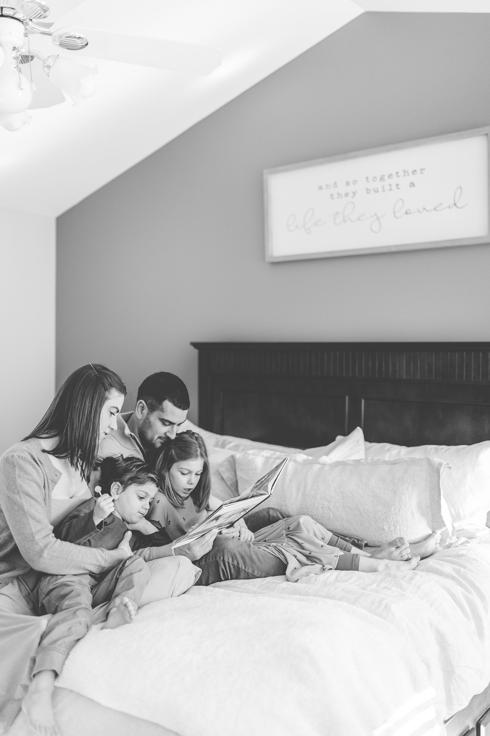 family reads together on bed during photos at home