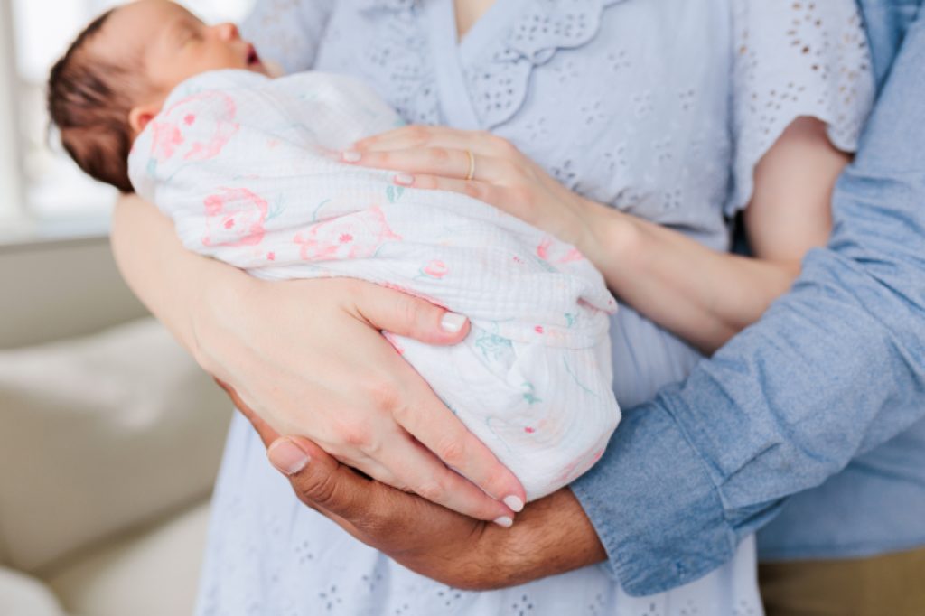 parents hold newborn baby during lifestyle newborn session