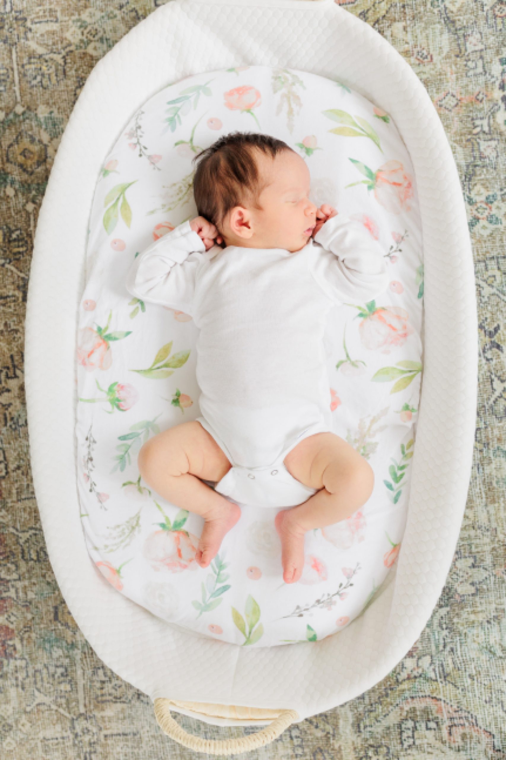 baby lays in bassinet in white onesie during lifestyle newborn session: outfit ideas for lifestyle newborn photos