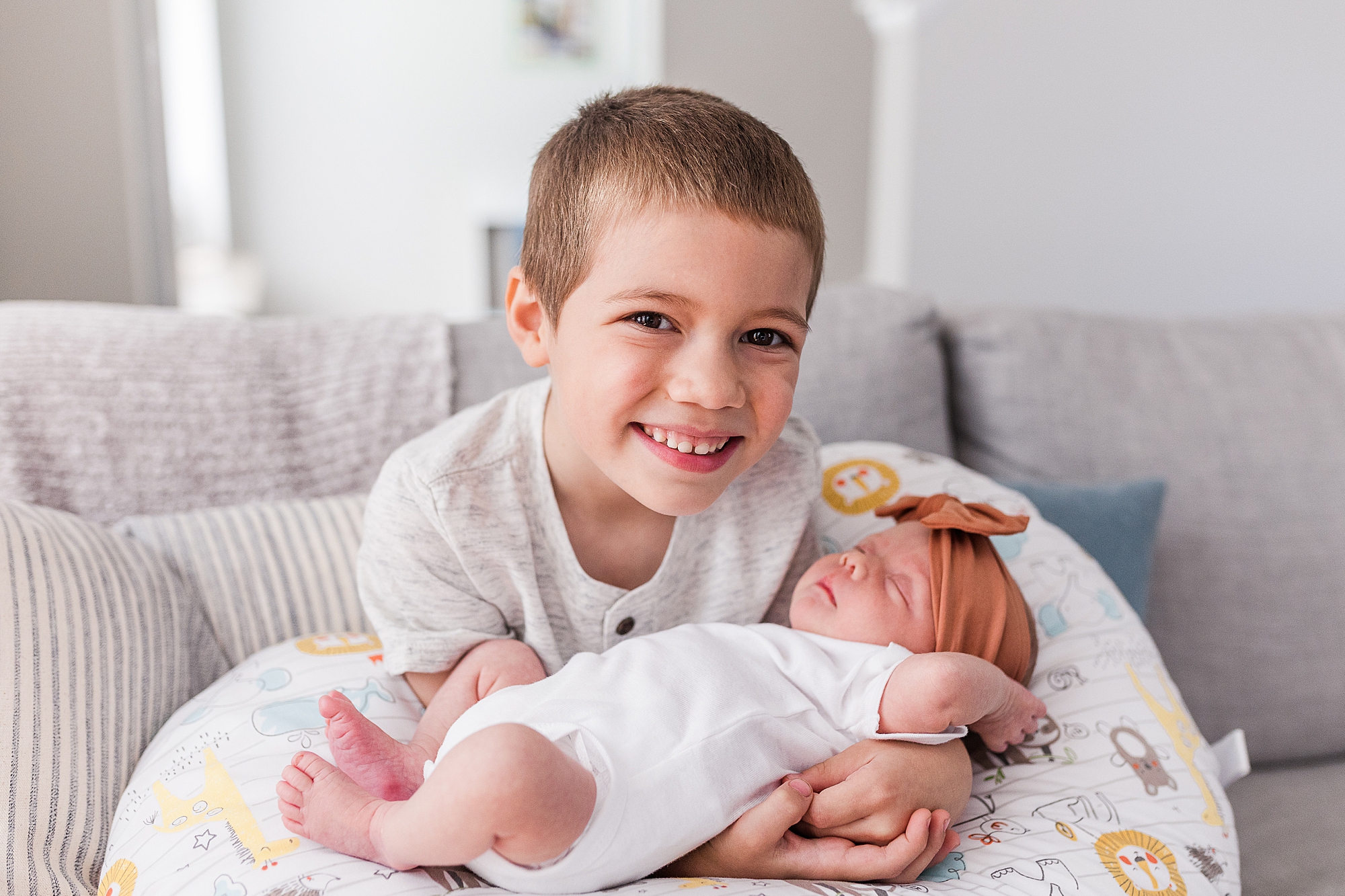 big brother holds newborn sister during photos at home