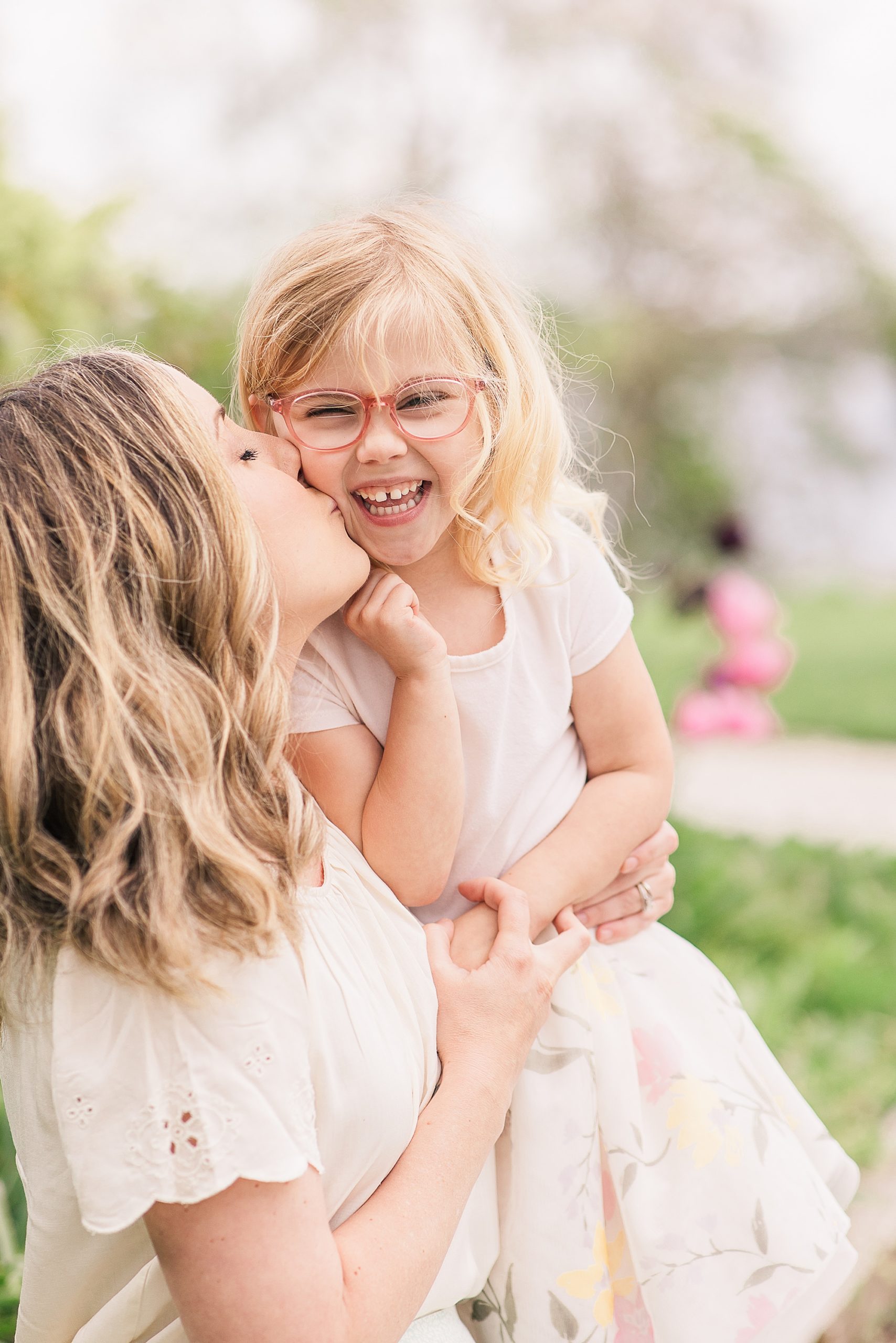 mom leans to kiss daughter's cheek during family photos in Annapolis MD