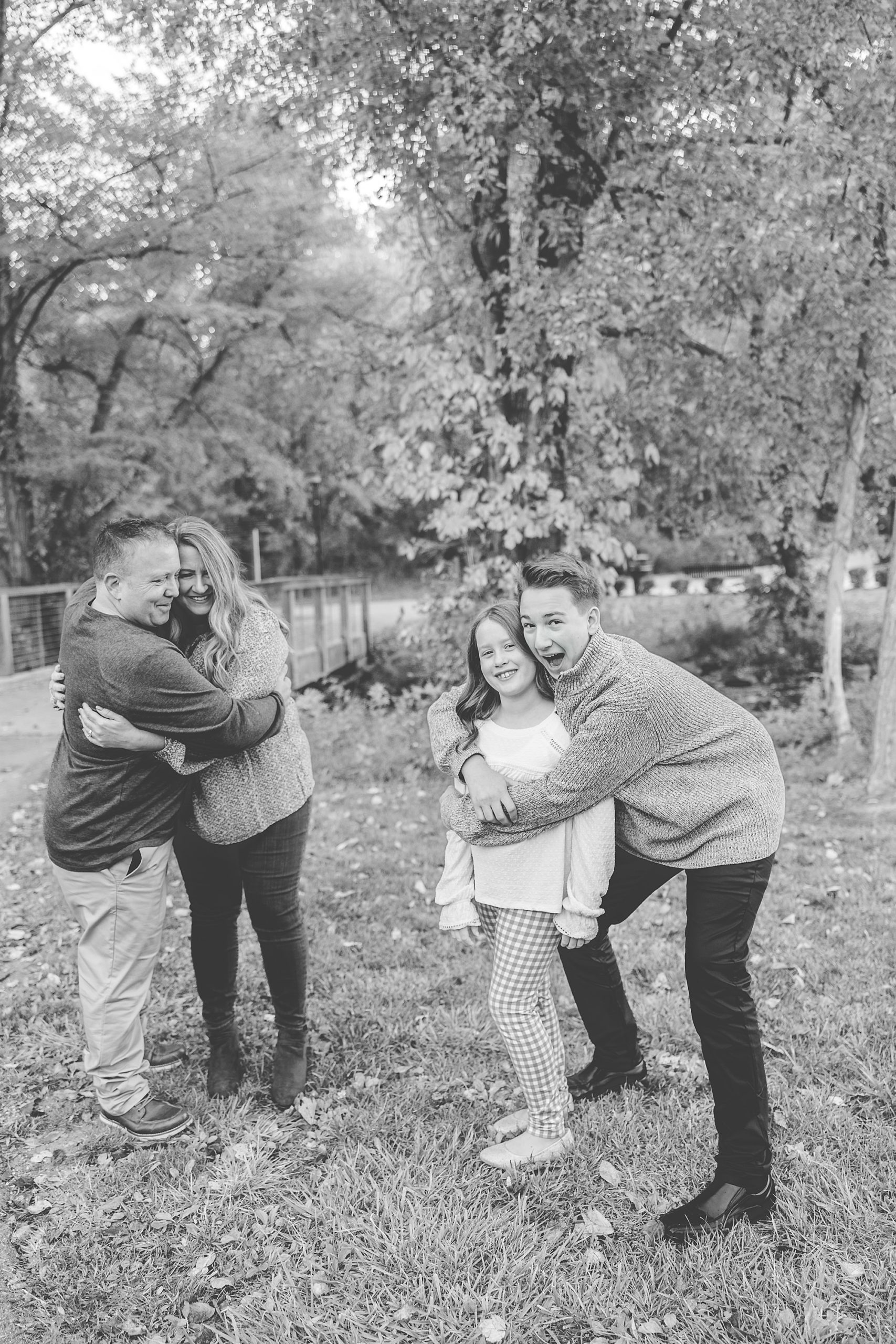 kids goof off while parents hug during family photos