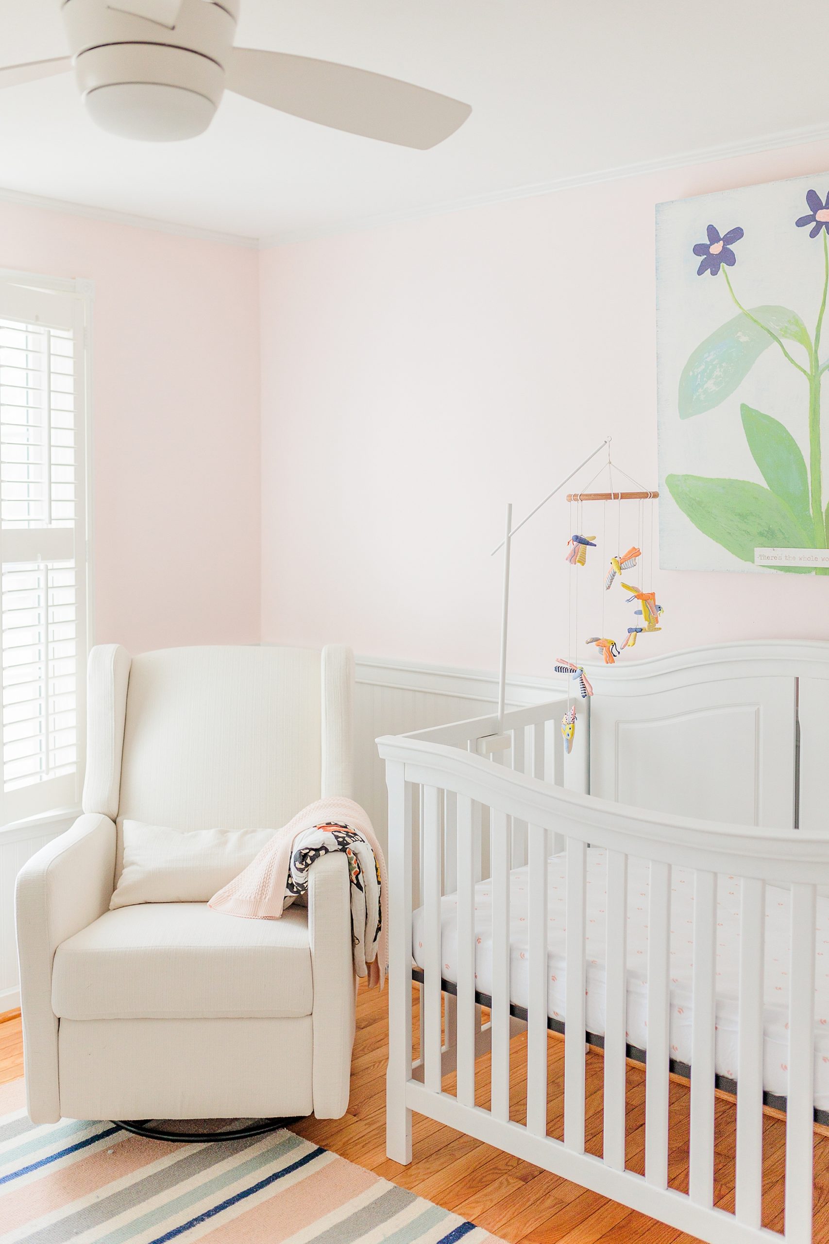 white rocker and crib in nature inspired nursery for baby girl 