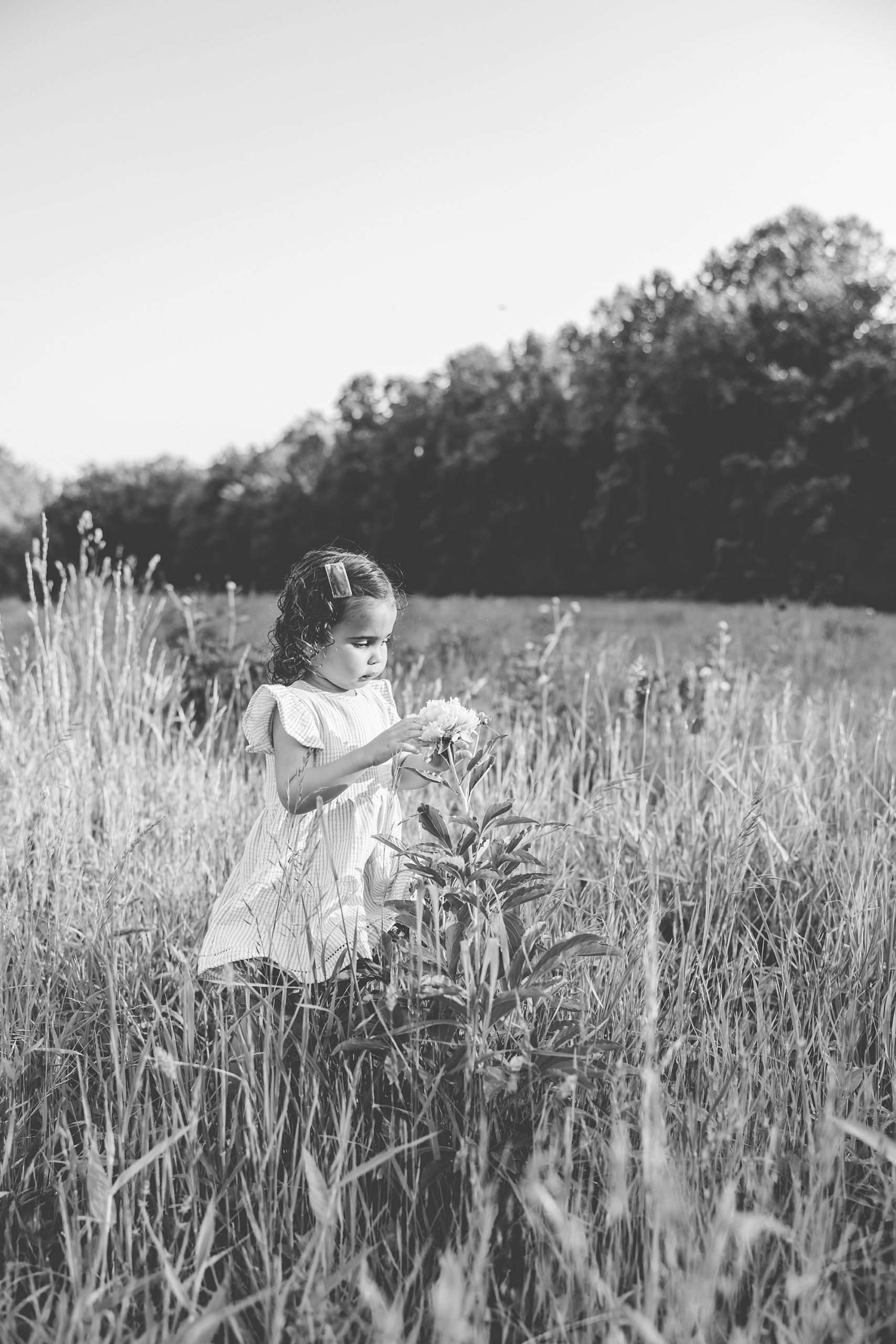 girl plays with peony in field in Gaithersburg MD