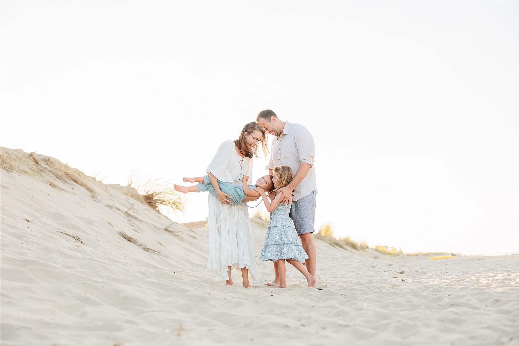 parents hug two kids on sands of Delaware Beach