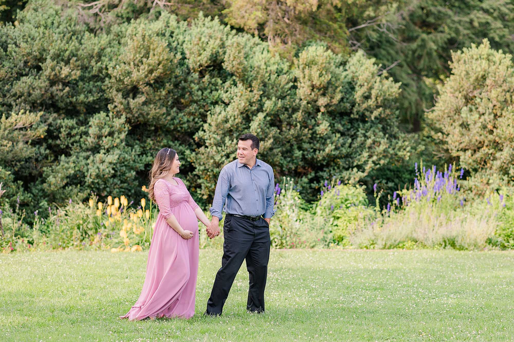 couple walks through gardens in Alexandria VA holding hands 