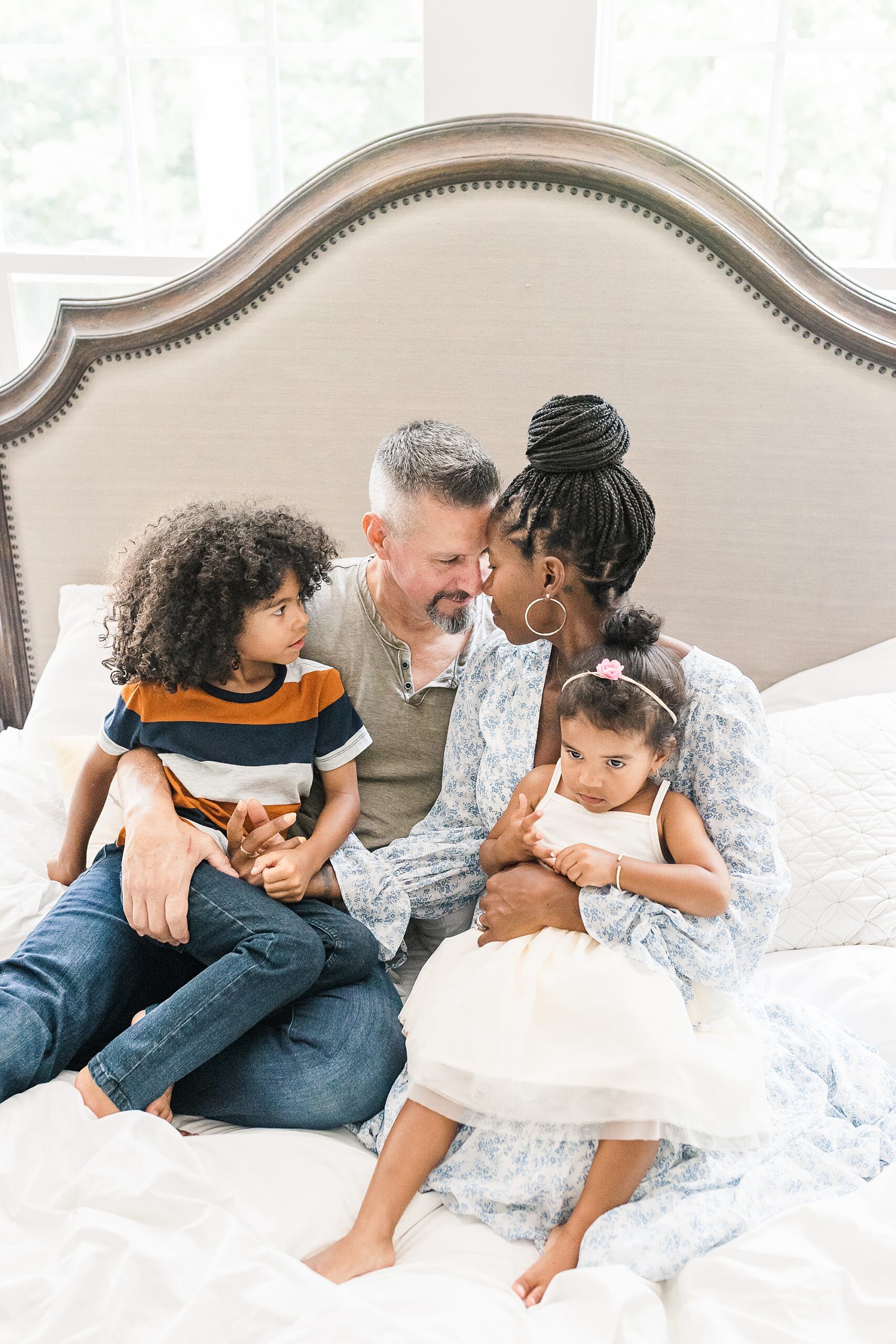 parents pose with children on bed in NOVA home