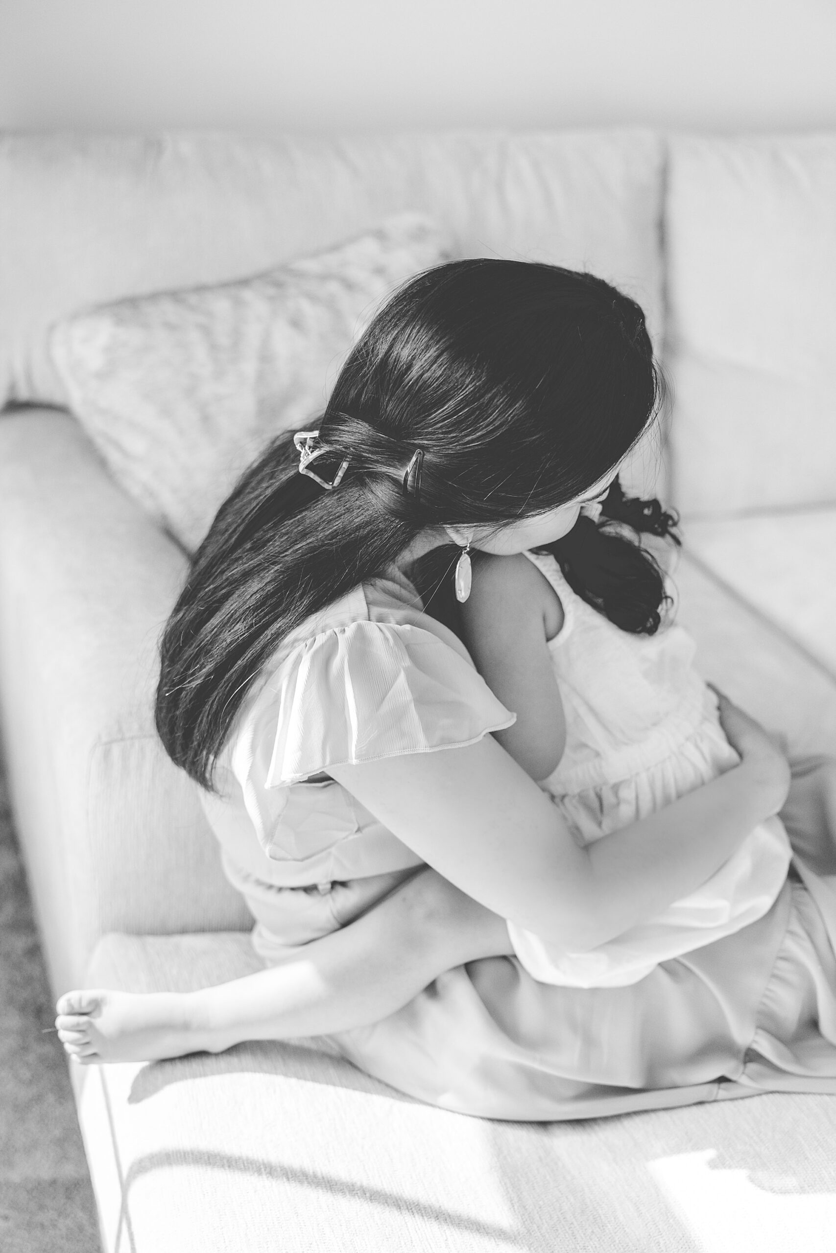 mom hugs daughter on lap during lifestyle family photos 