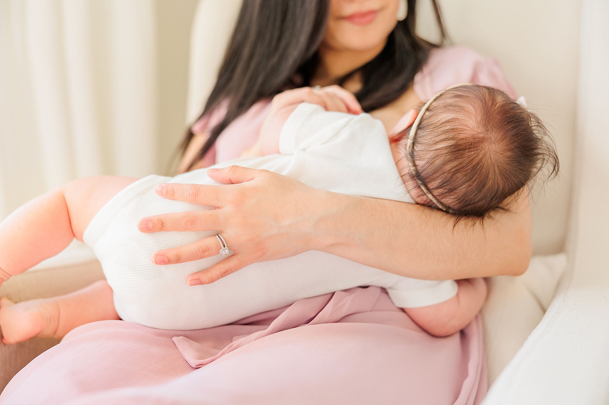 mom rocks baby in nursery during lifestyle newborn photos 