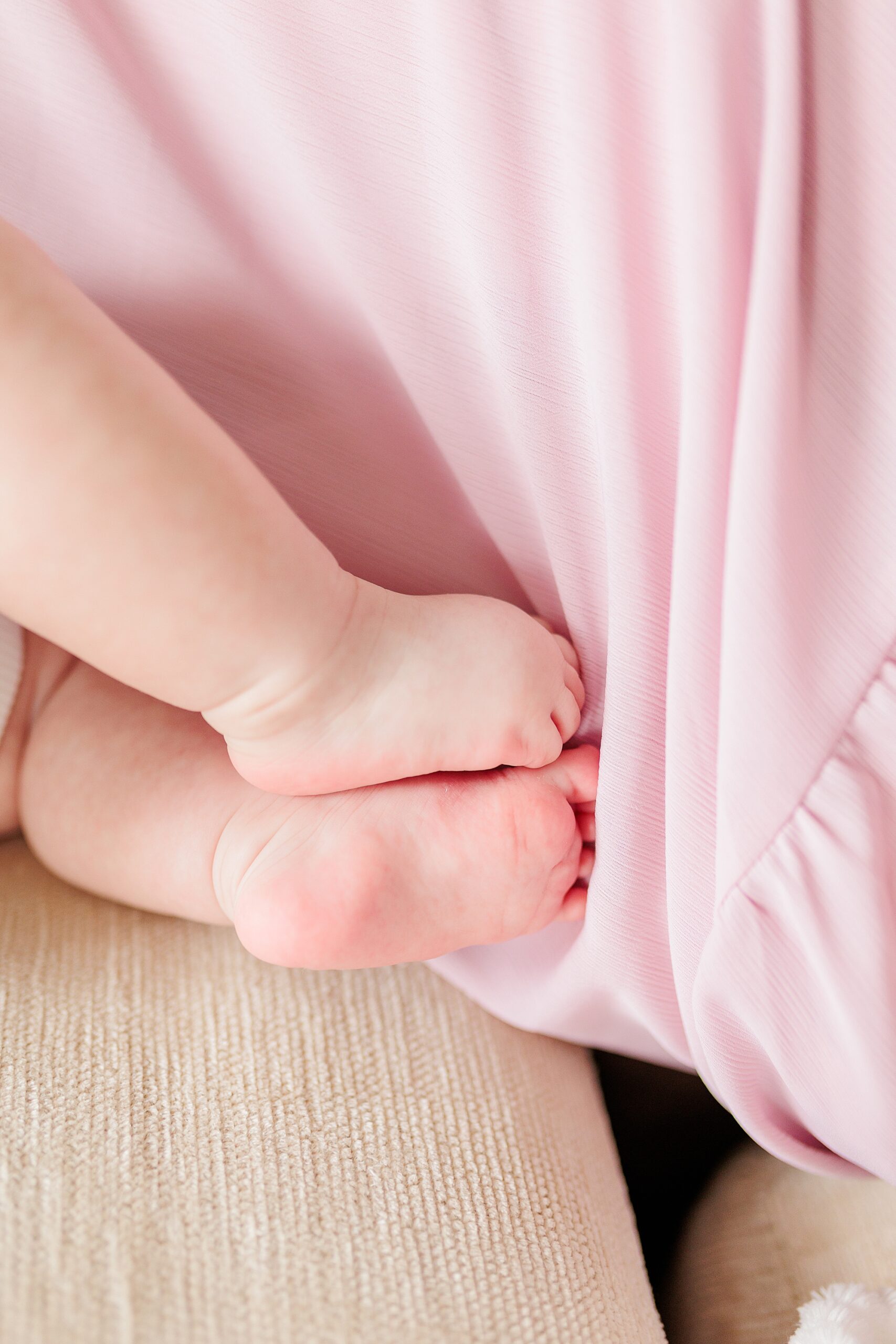 baby toes tucked into mom's pink dress during Chevy Chase new life session photographed by Northern Virginia family photographer Christina Tundo Photography 