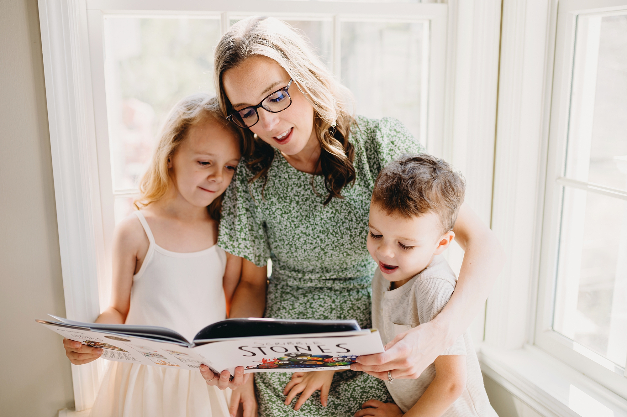 mom in green dress reads to son and daughter 