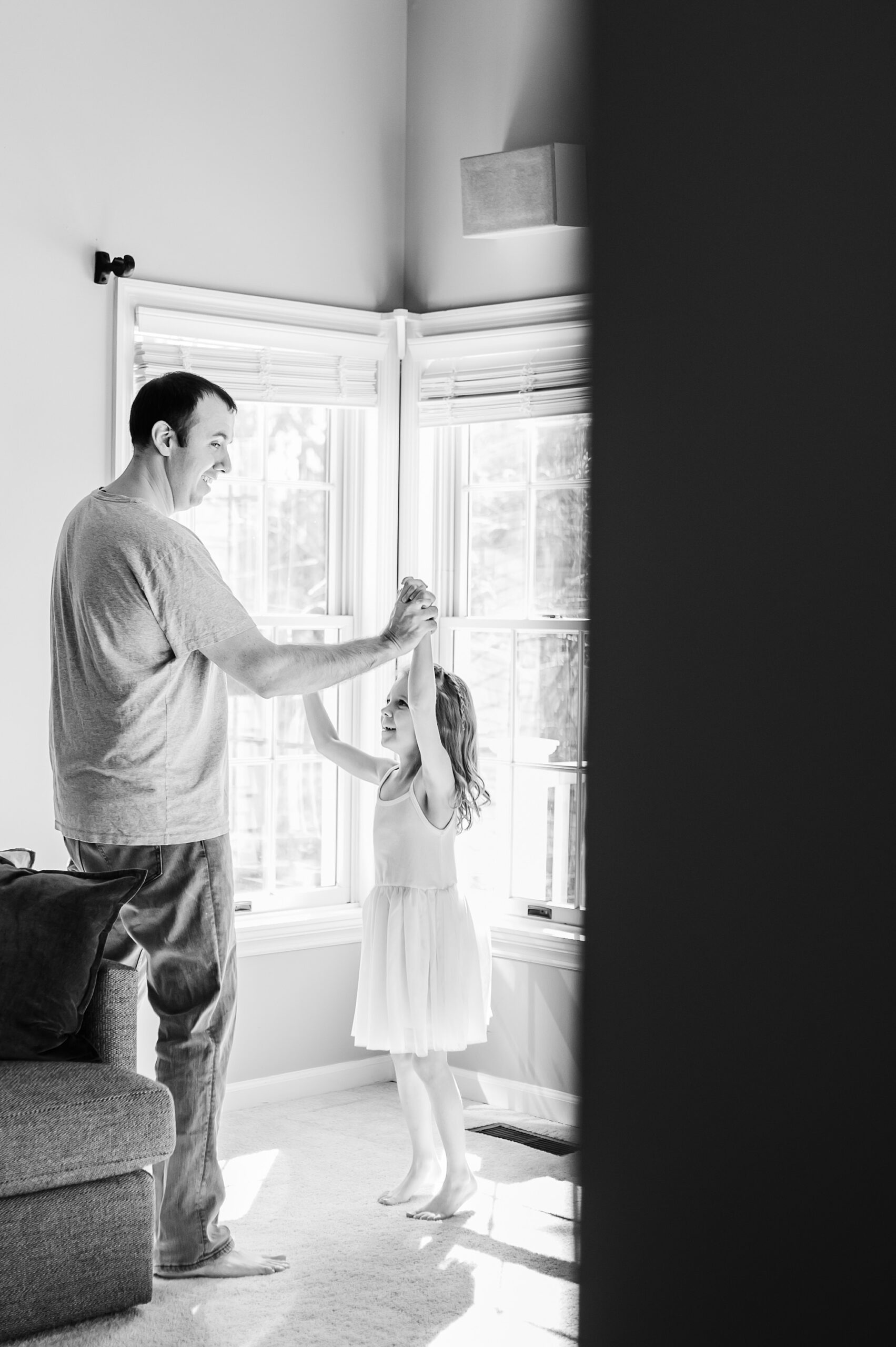 dad twirls daughter in room at home 