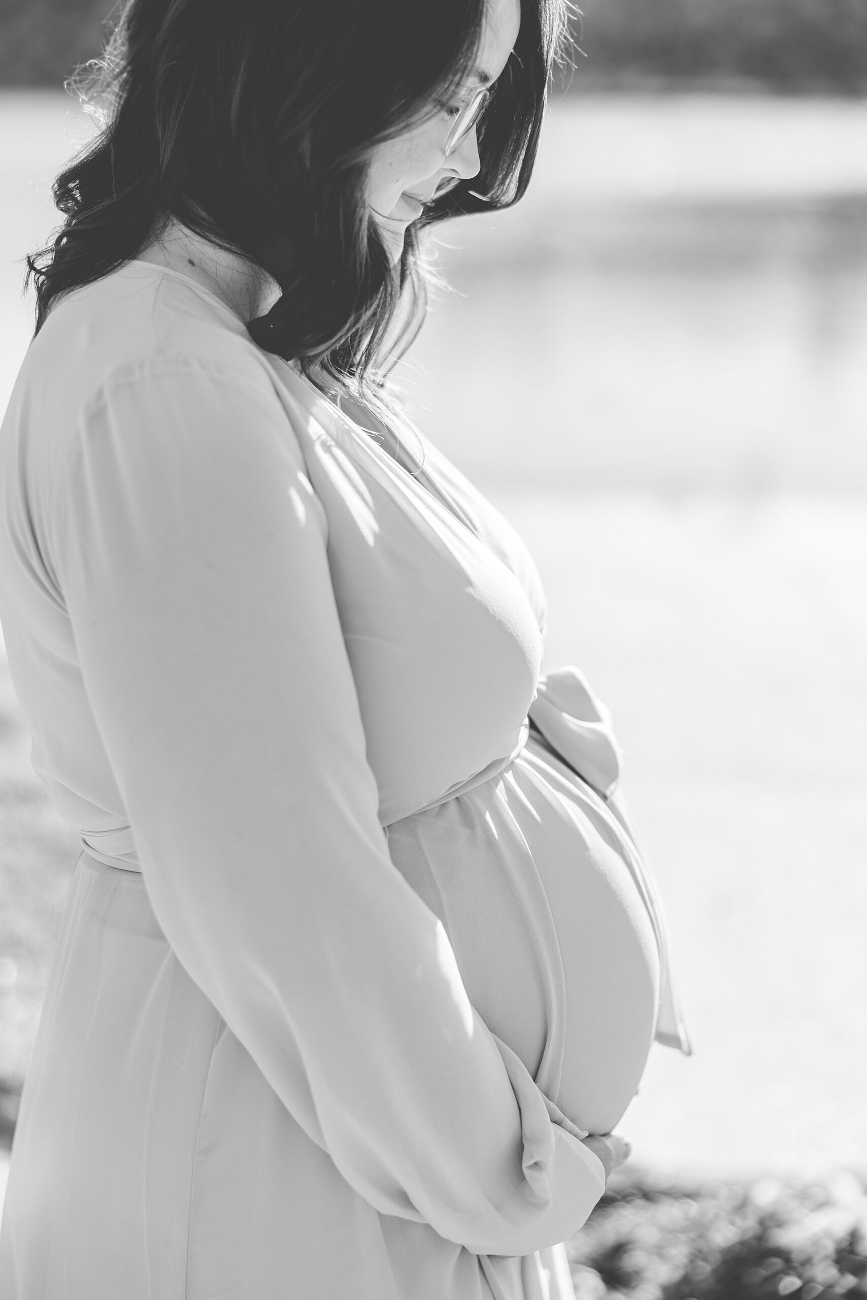 black and white portrait of mom holding pregnant belly 