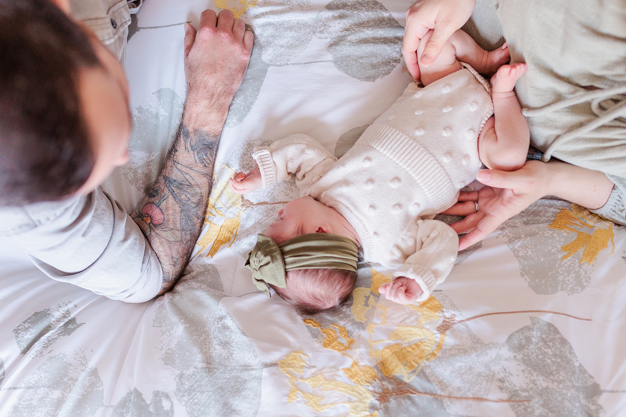 dad lays with daughters on bed during Maryland newborn lifestyle photos