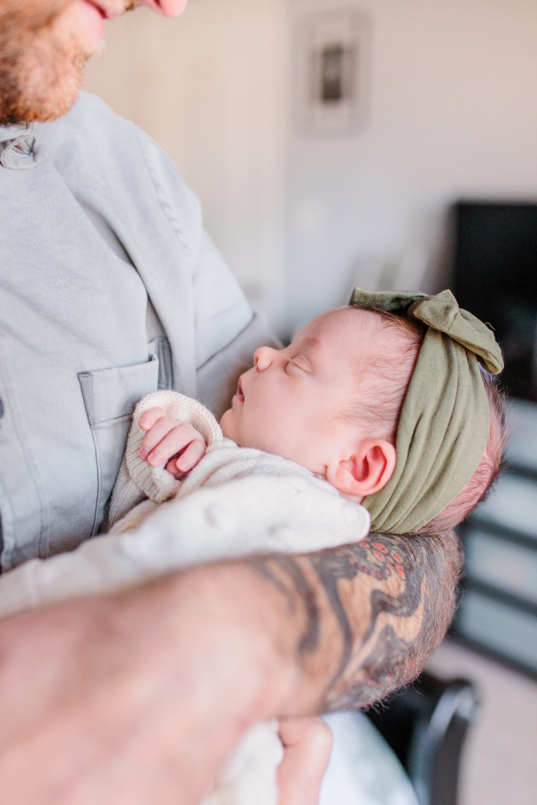 dad holds newborn daughter with green headband during Maryland newborn lifestyle photos