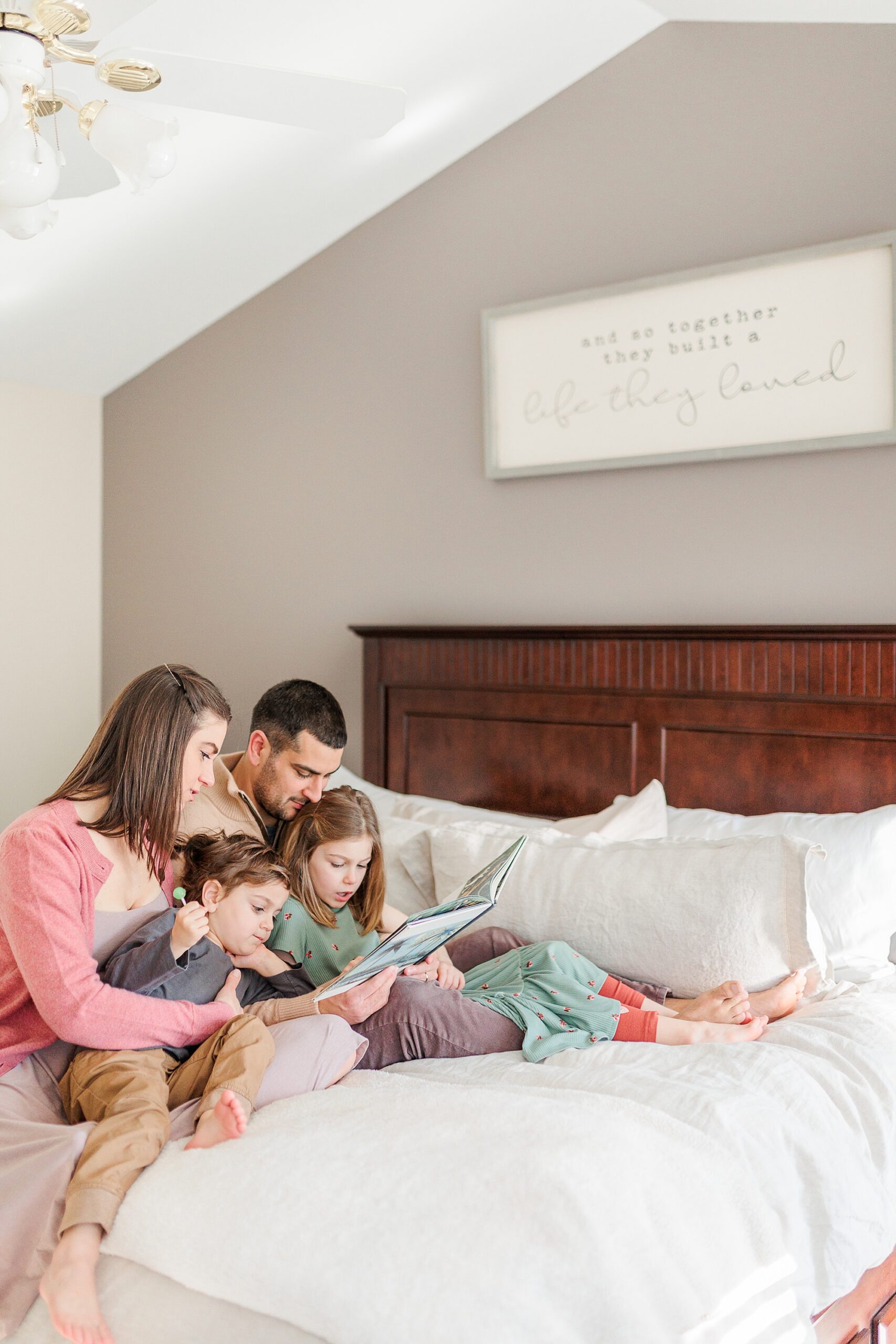parents read book with kids on bed in Baltimore home