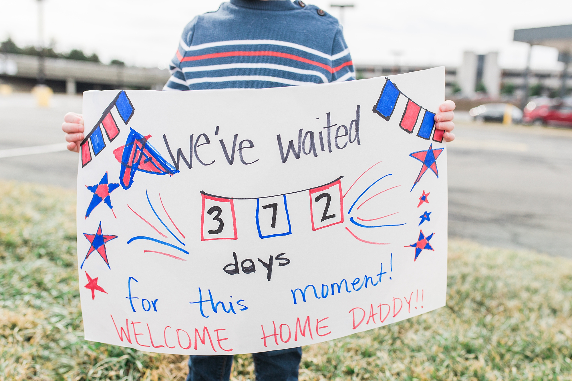 boy holds sign to welcome father home from military deployment 